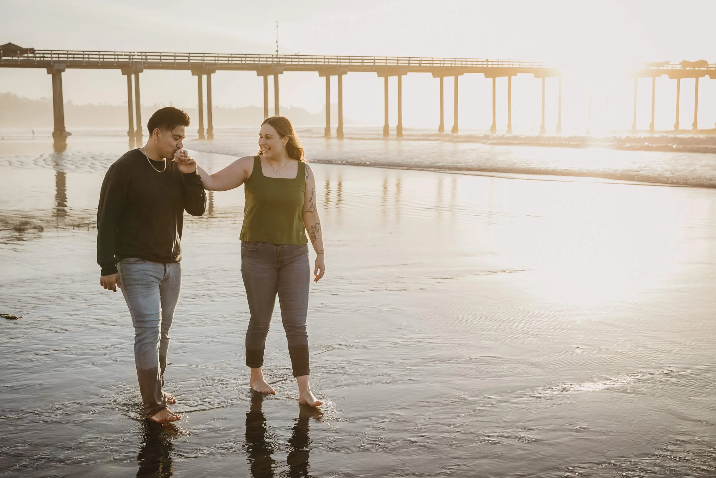 Groom to be kissing the hand of his fiancee on La Jolla Shores beach session during the sunset