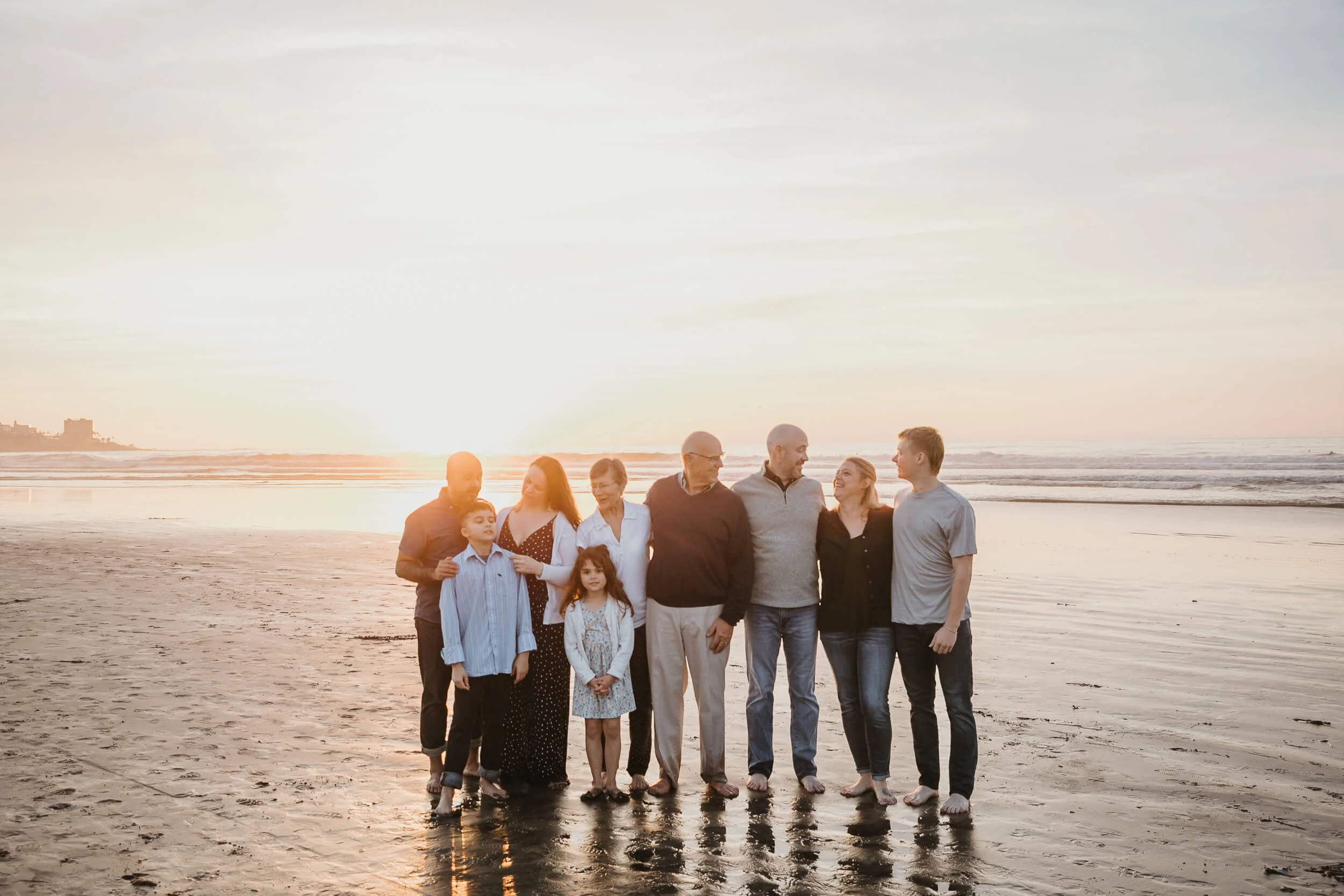 Candid moment of full family before the posed photo, where everybody was chatting and having fun during their La Jolla Shores and Scripps Pier Family Photography in San Diego