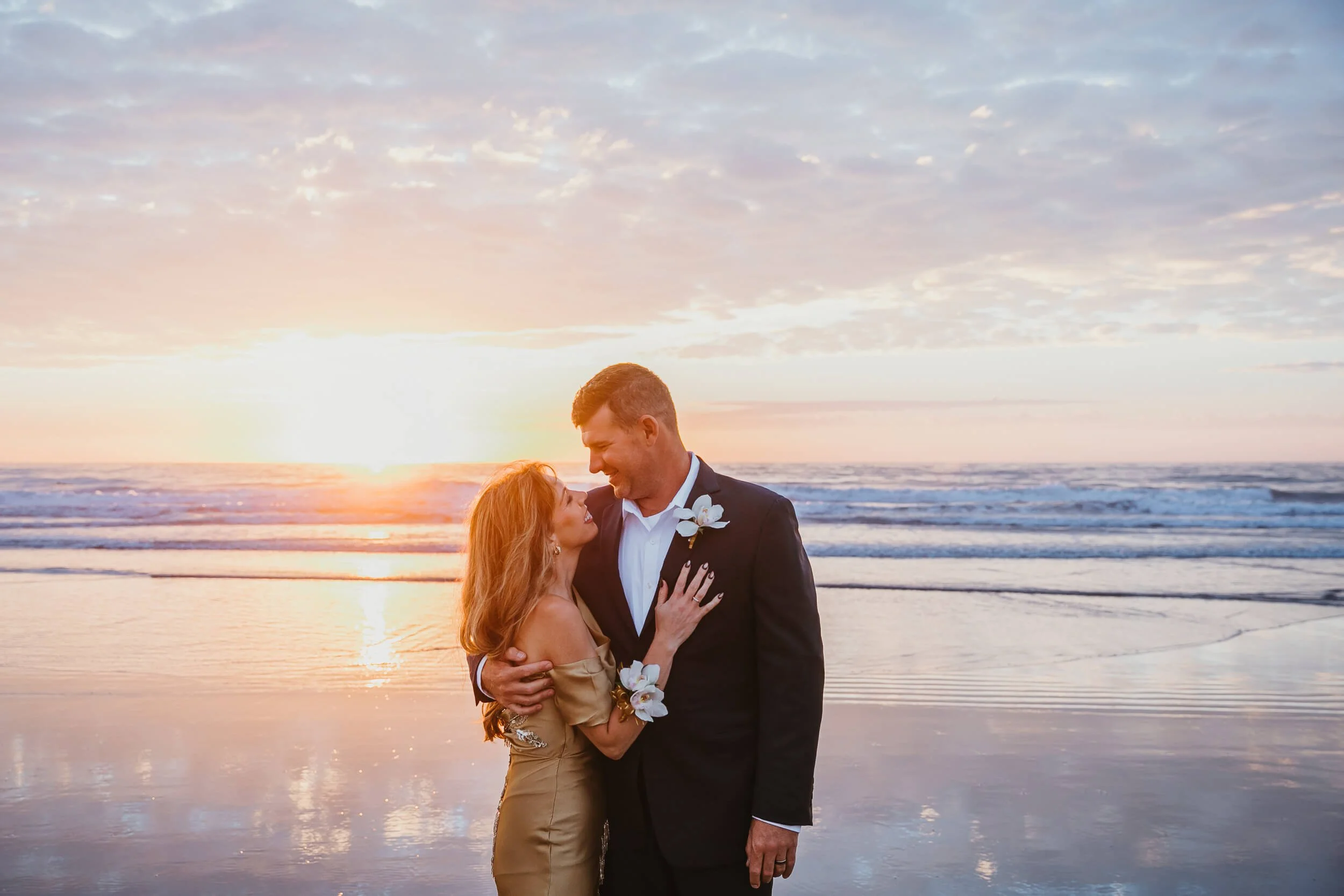 amazing golden hour light for couple looking at each other at La Jolla Shores Beach in San Diego