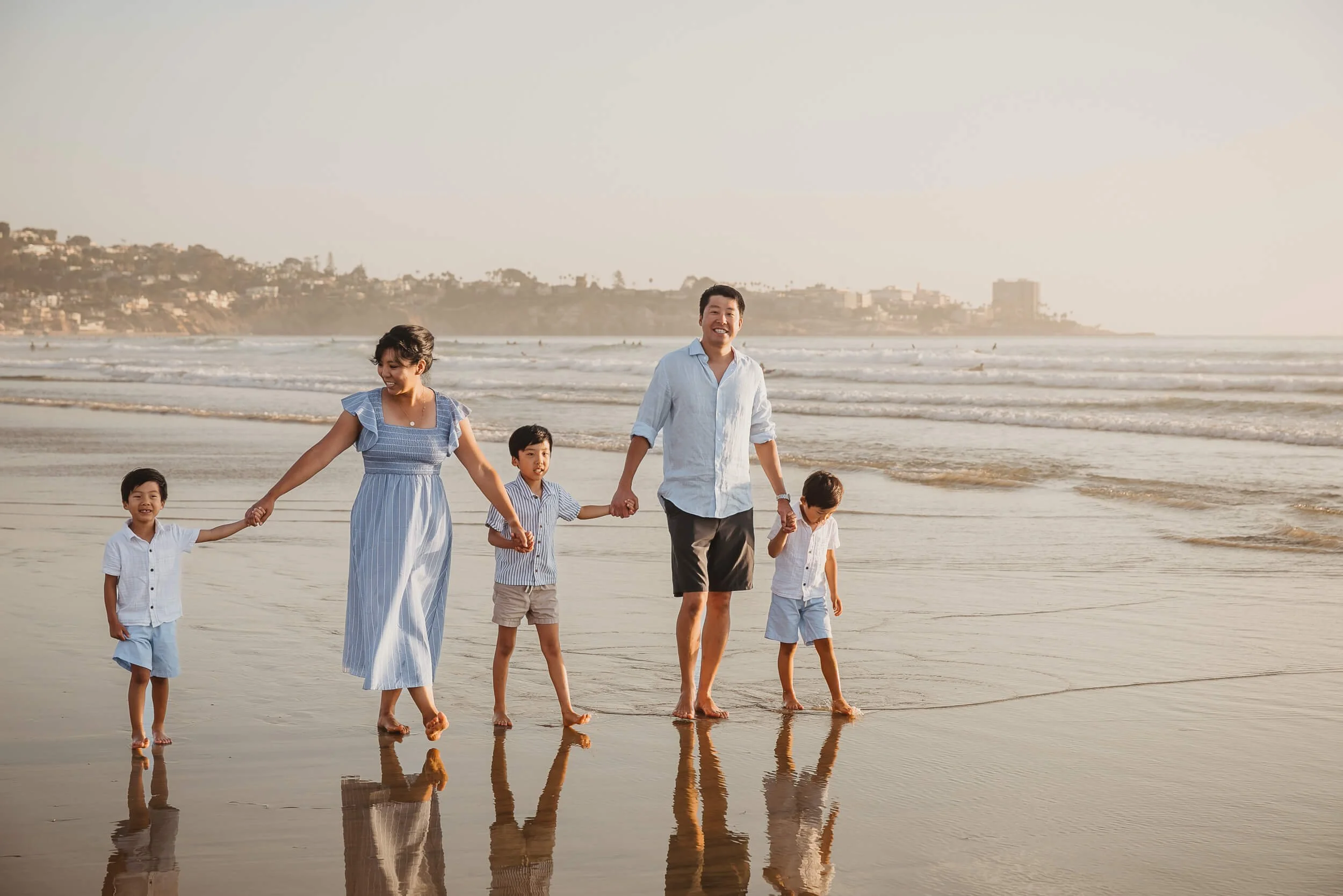 Parents and three boys walking along the shore at La Jolla Shores Beach during San Diego photography session
