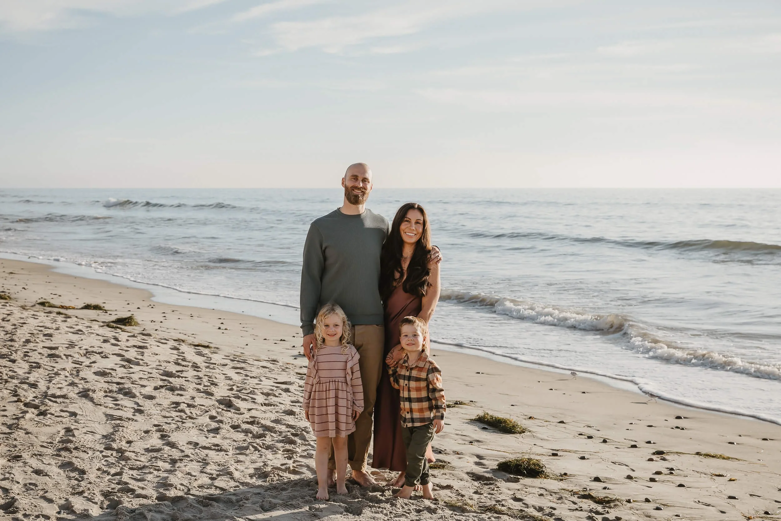 Beach family portrait with ocean waves in the background during a Carlsbad Beach Family Photography Session