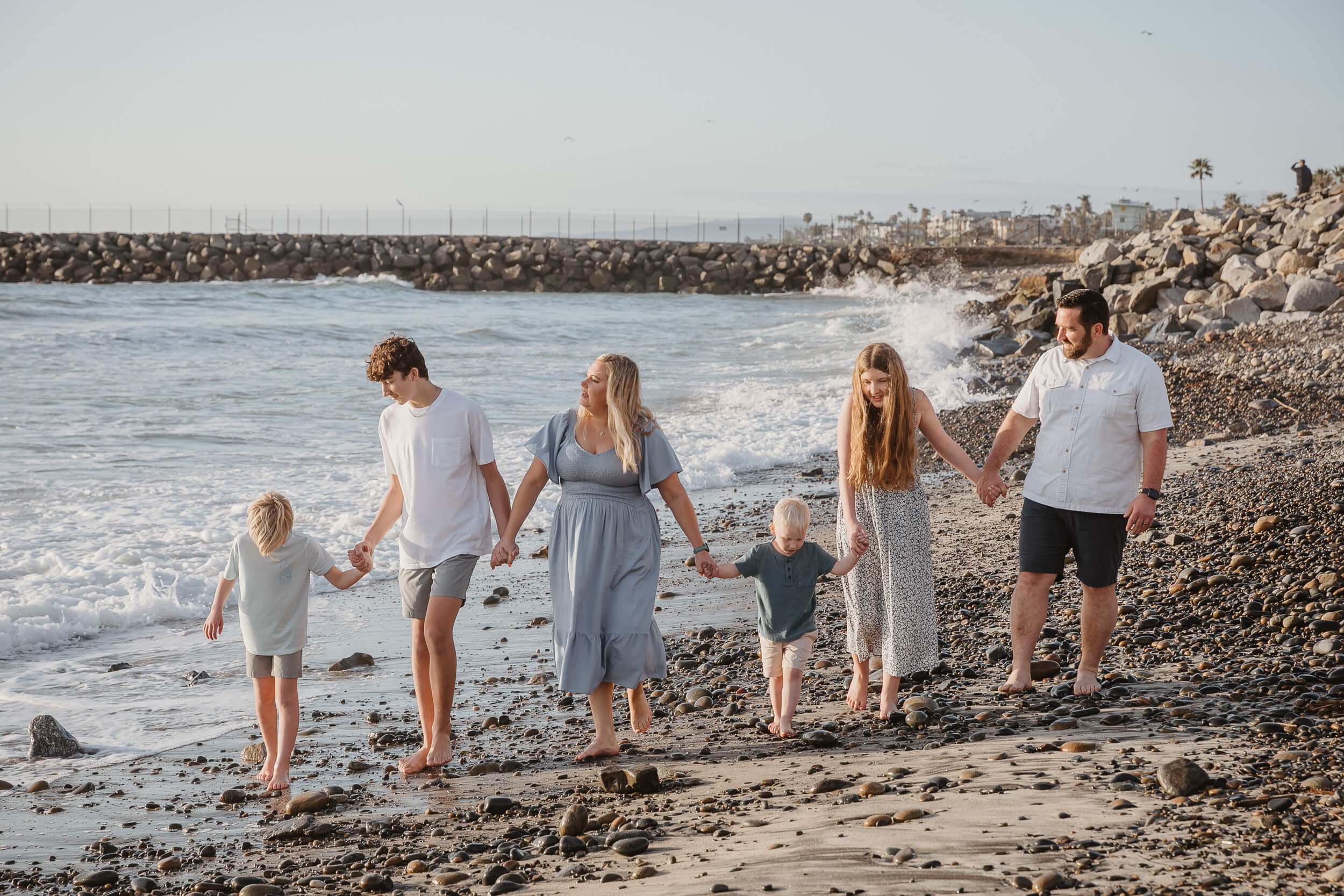 Family holding hands by the ocean during a Carlsbad Beach Family Photography Session