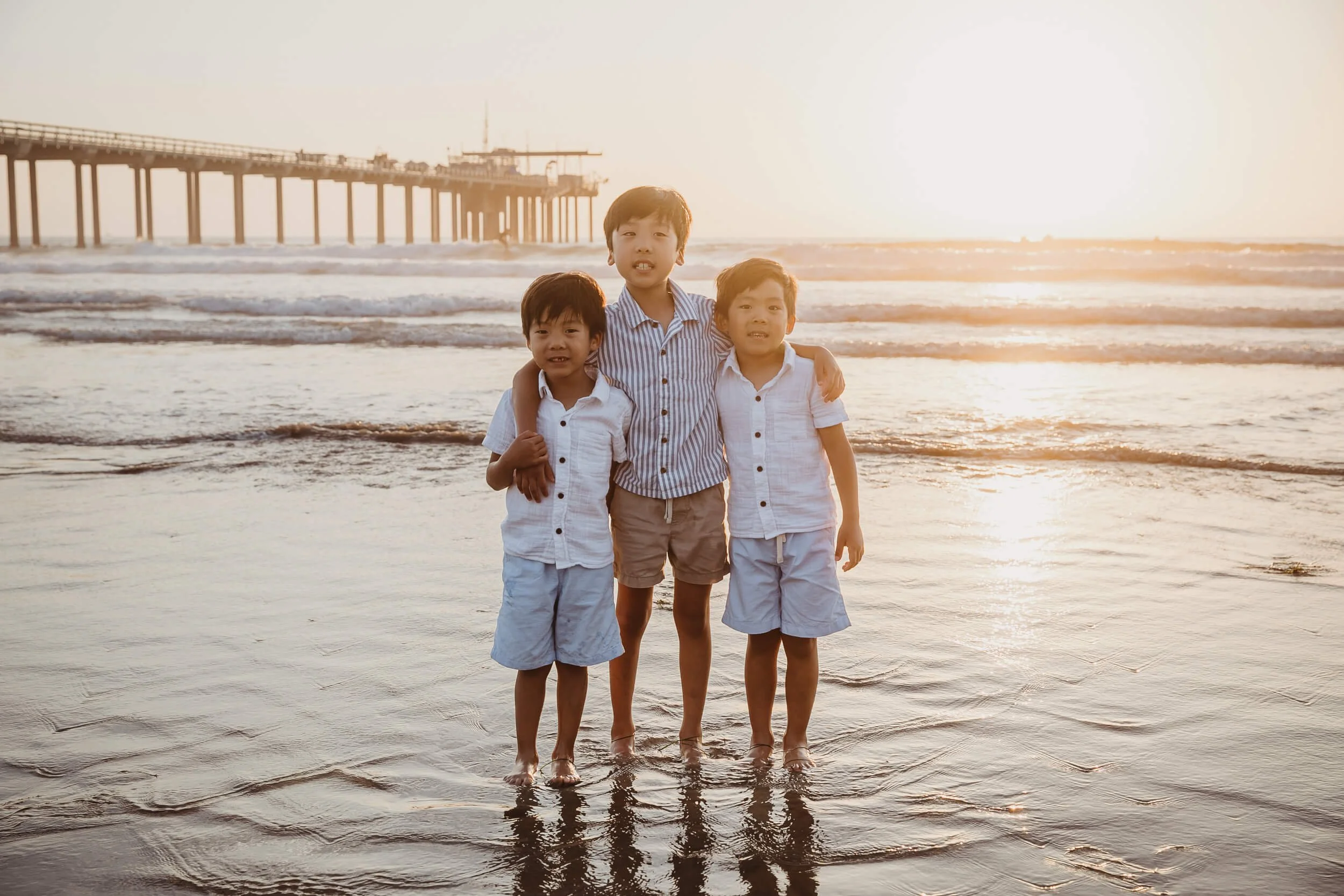 Boys posing for brother's photo during the sunset at La Jolla Shores and Scripps Pier Family Photography in San Diego