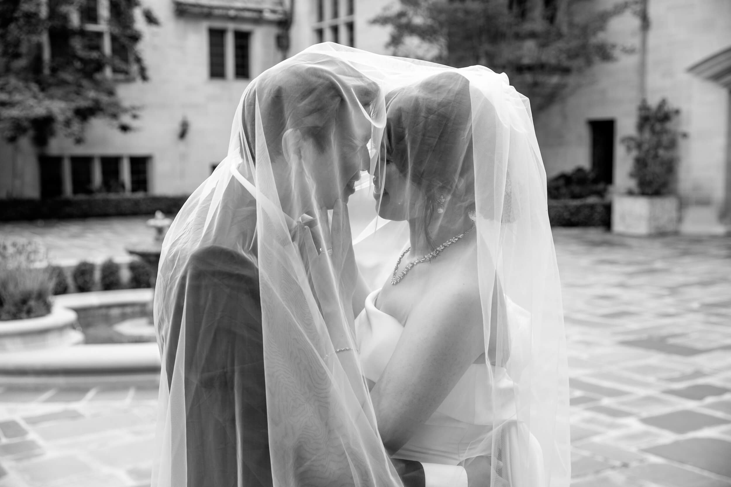 Black and white couole under veil at Greystone Mansion and Gardens Engagement Photos