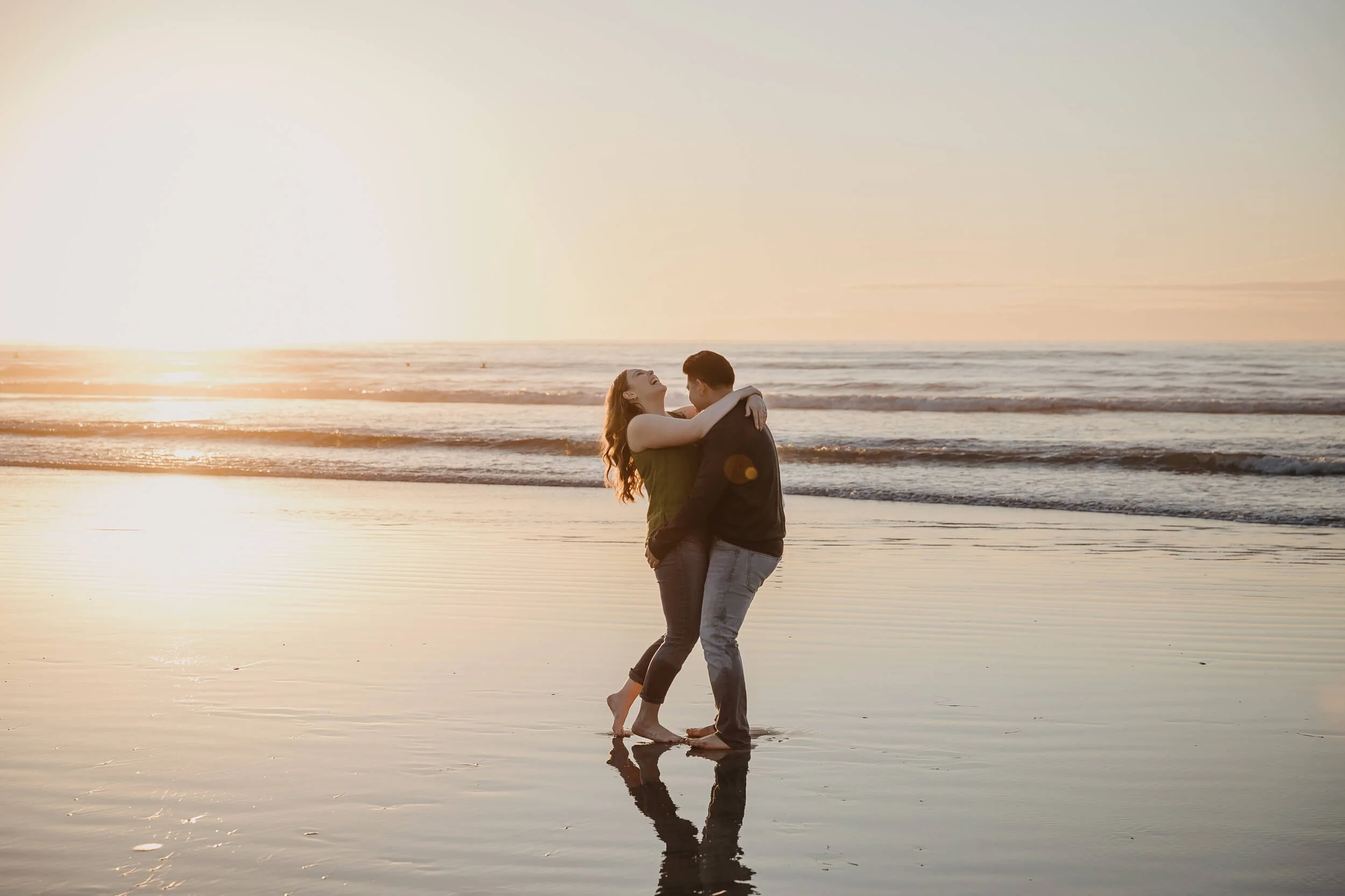 Couple having fun together during golden hour at La Jolla Shores and Scripps pir photo session 