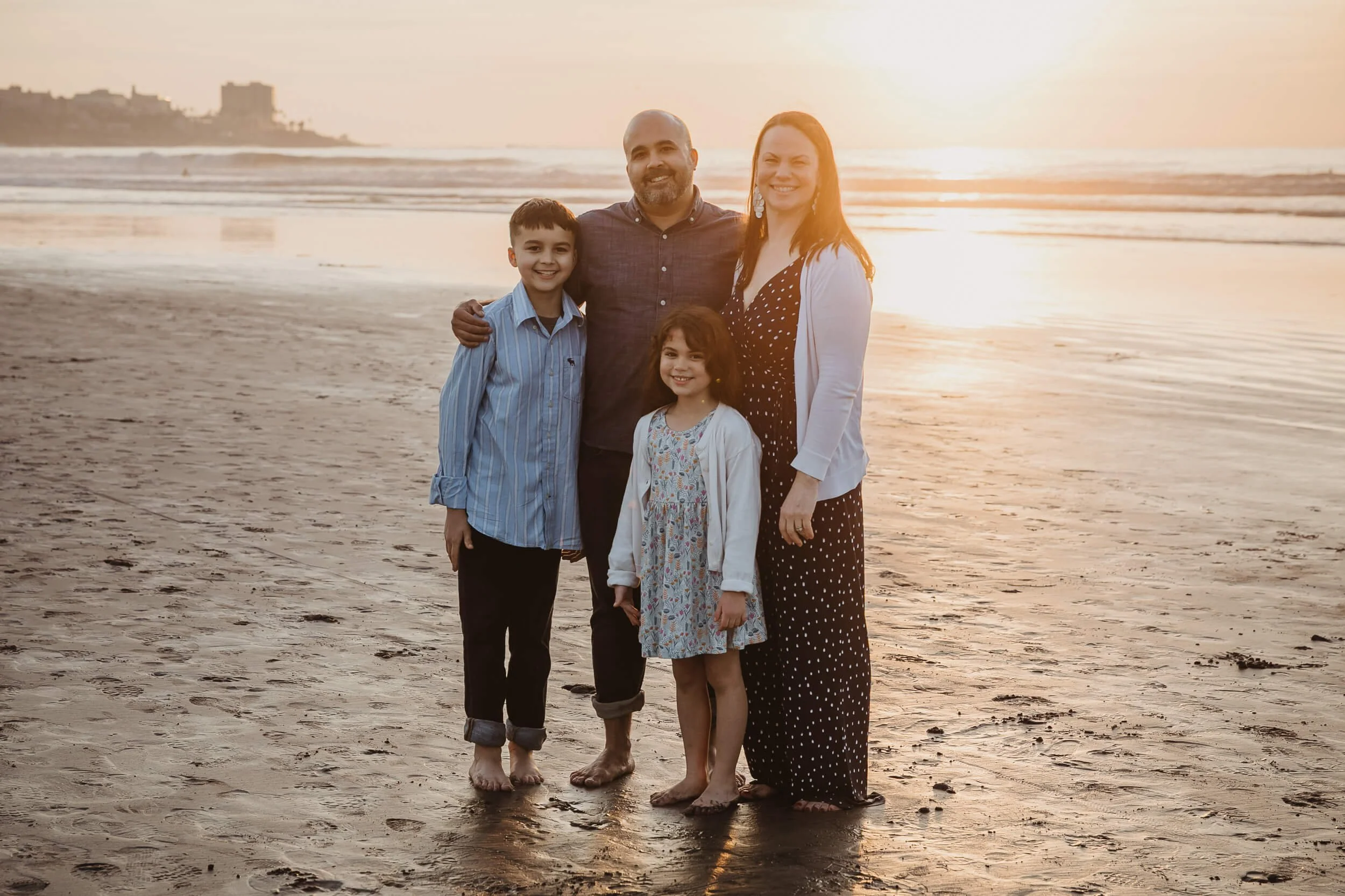 Golden hour family portrait session at La Jolla Shores couple looking at camera and smilling 