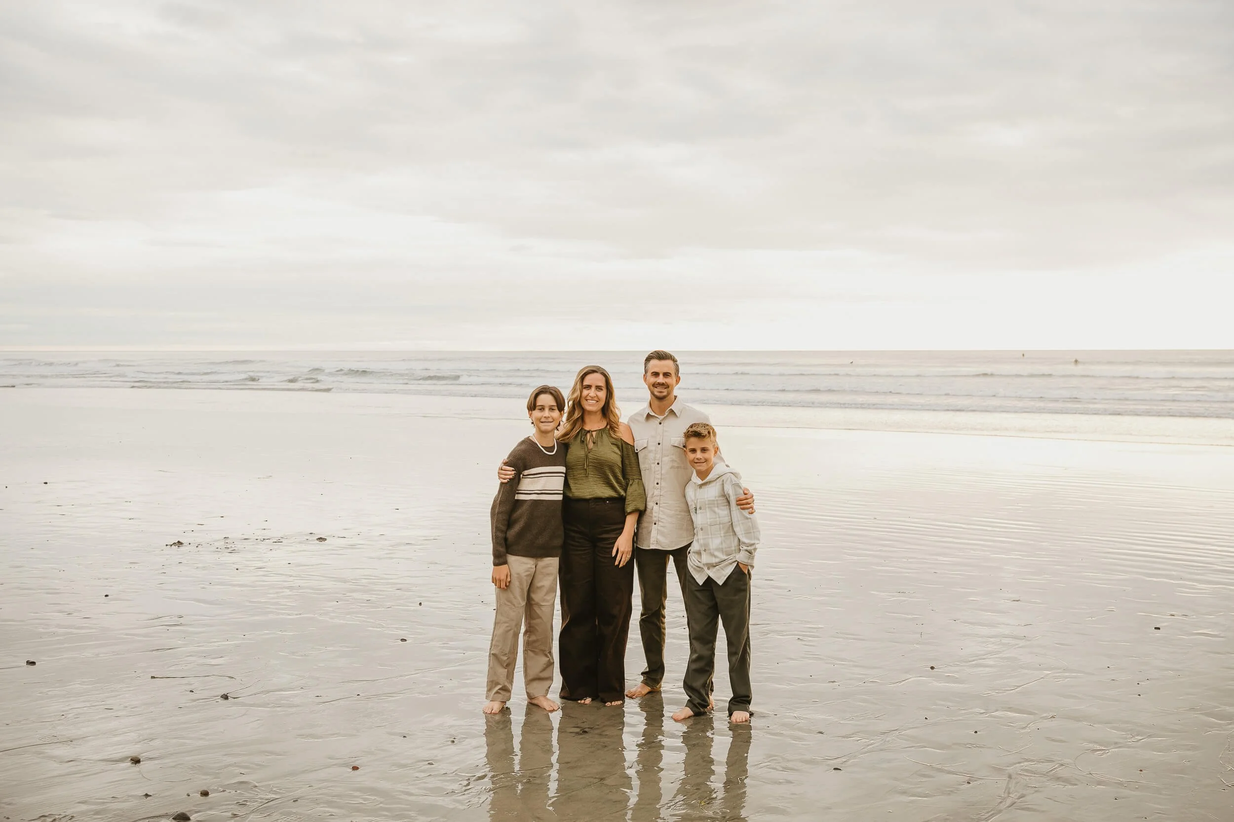 Beach family portrait with reflections in the wet sand during sunset in Carlsbad, California