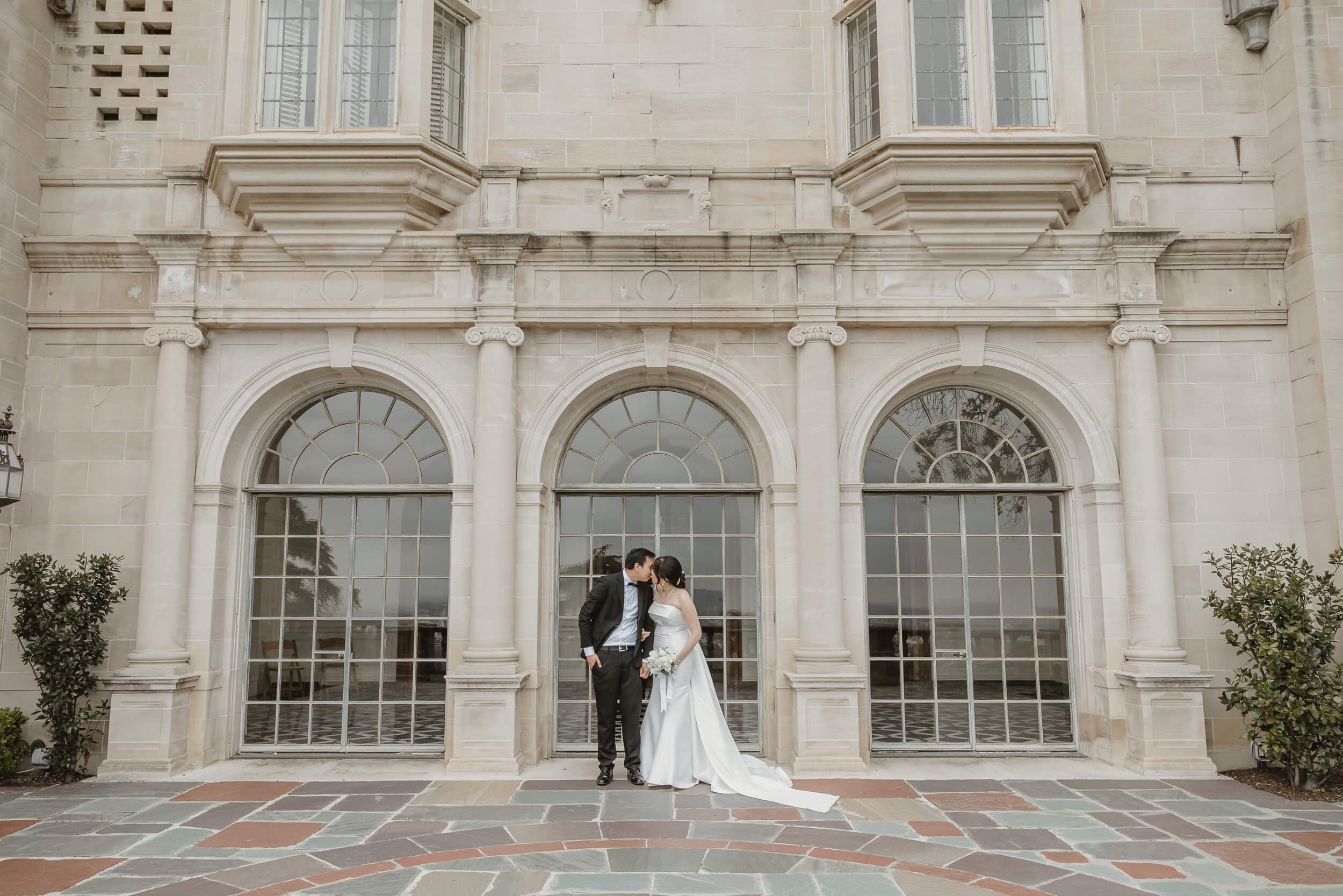 Couple looking at each other in front of Greystone Mansion and Gardens for engagement photography session in Beverly Hills