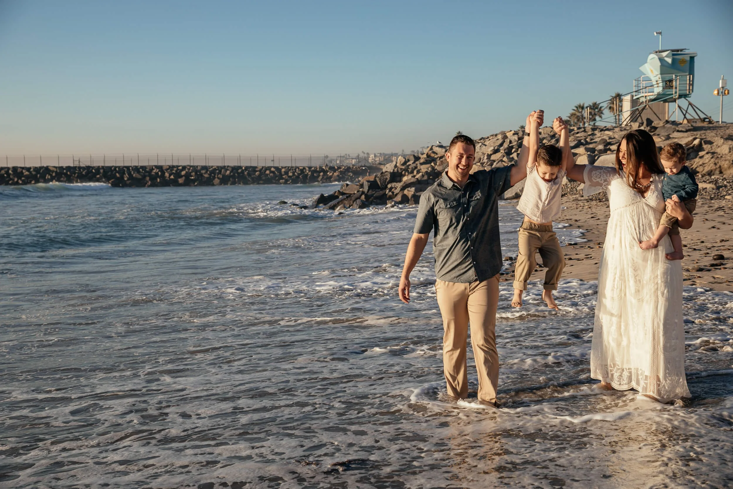 Candid family moment playing in the waves during a Carlsbad Beach Family Photography Session