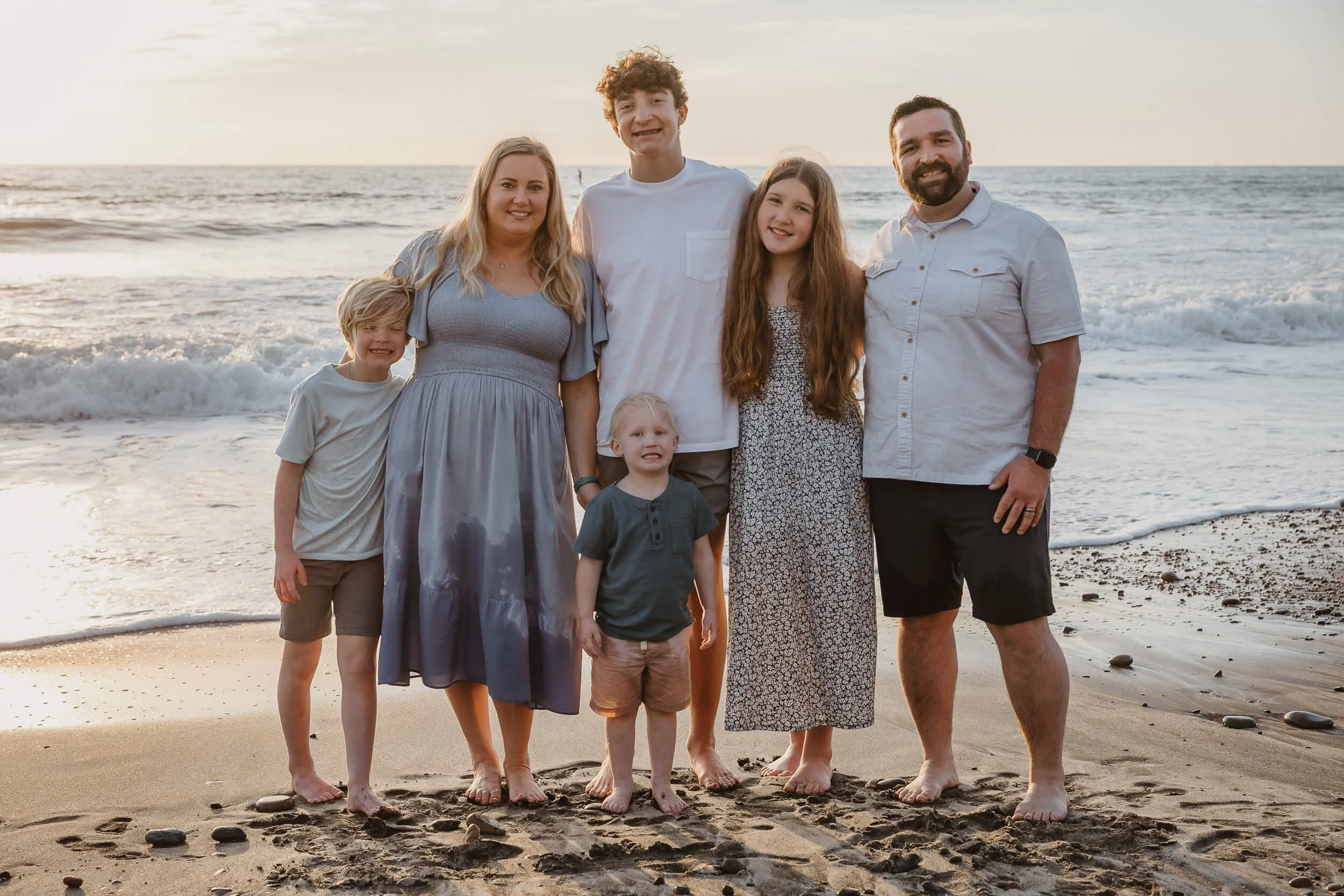 Family portrait standing together by the ocean during a Carlsbad Beach Family Photography Session