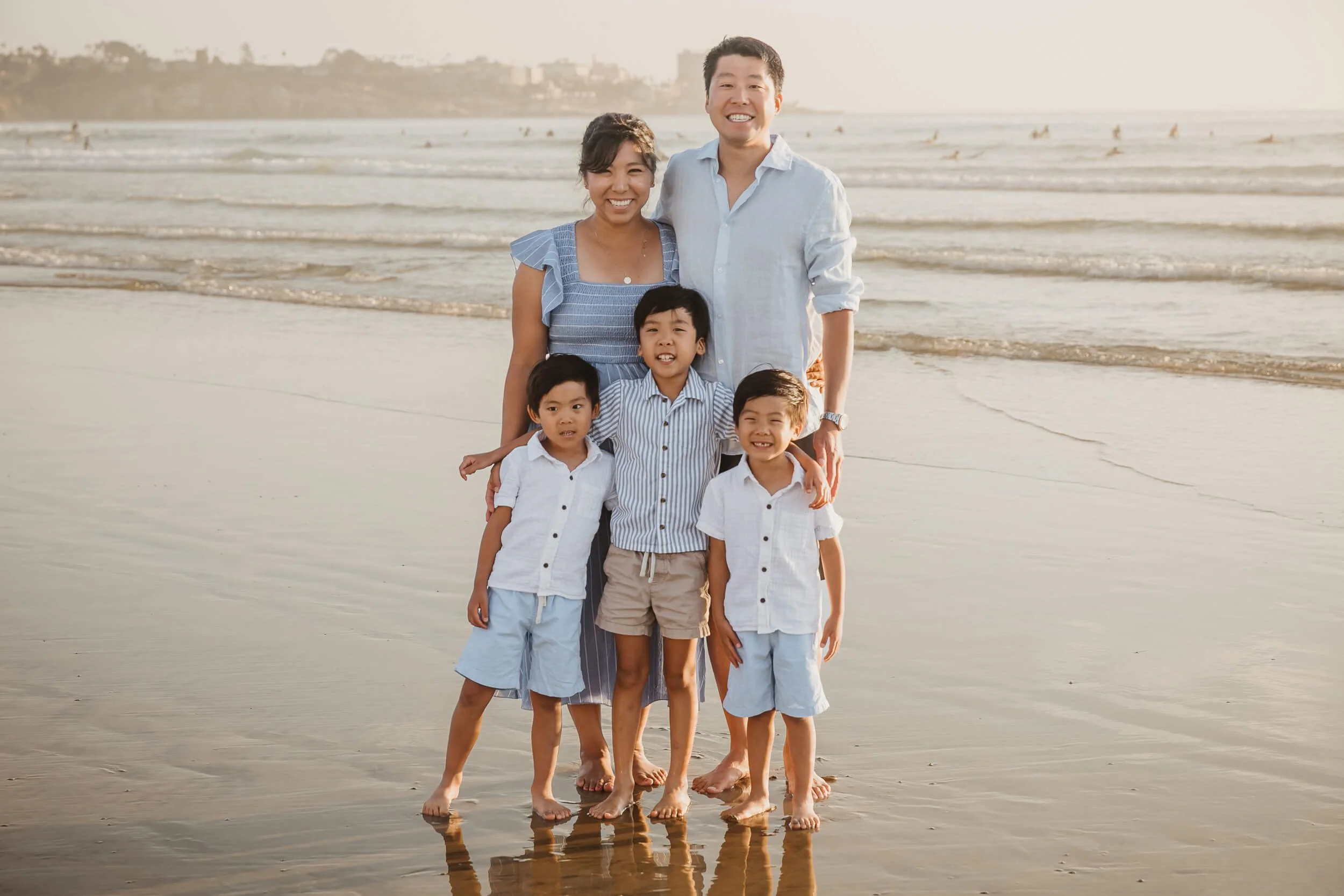 Mom, dad, and three boys at La Jolla Shores and Scripps Pier Family Photography in San Diego posing looking at camera