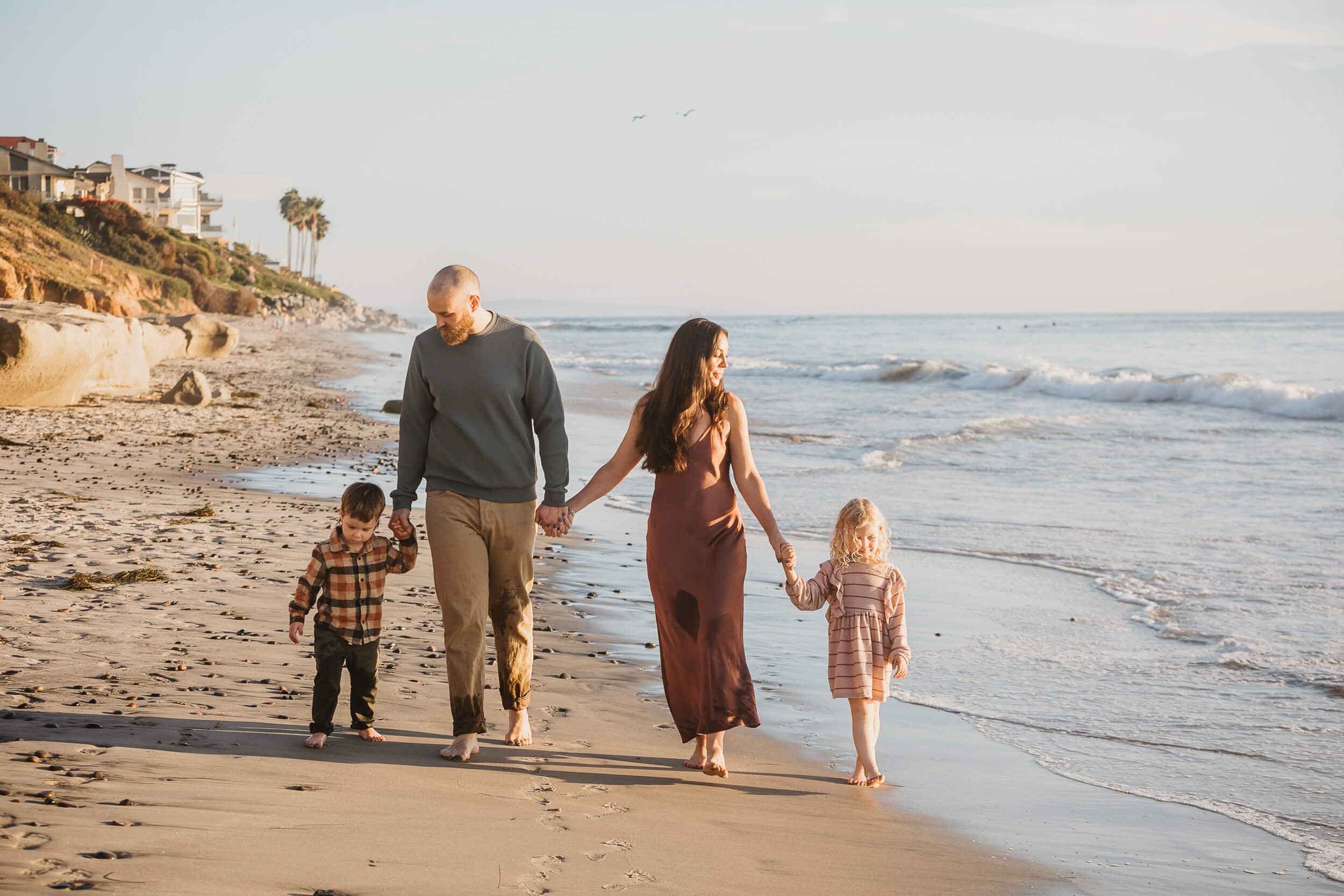 Family walking together along the shoreline during a Carlsbad Beach Family Photography Session