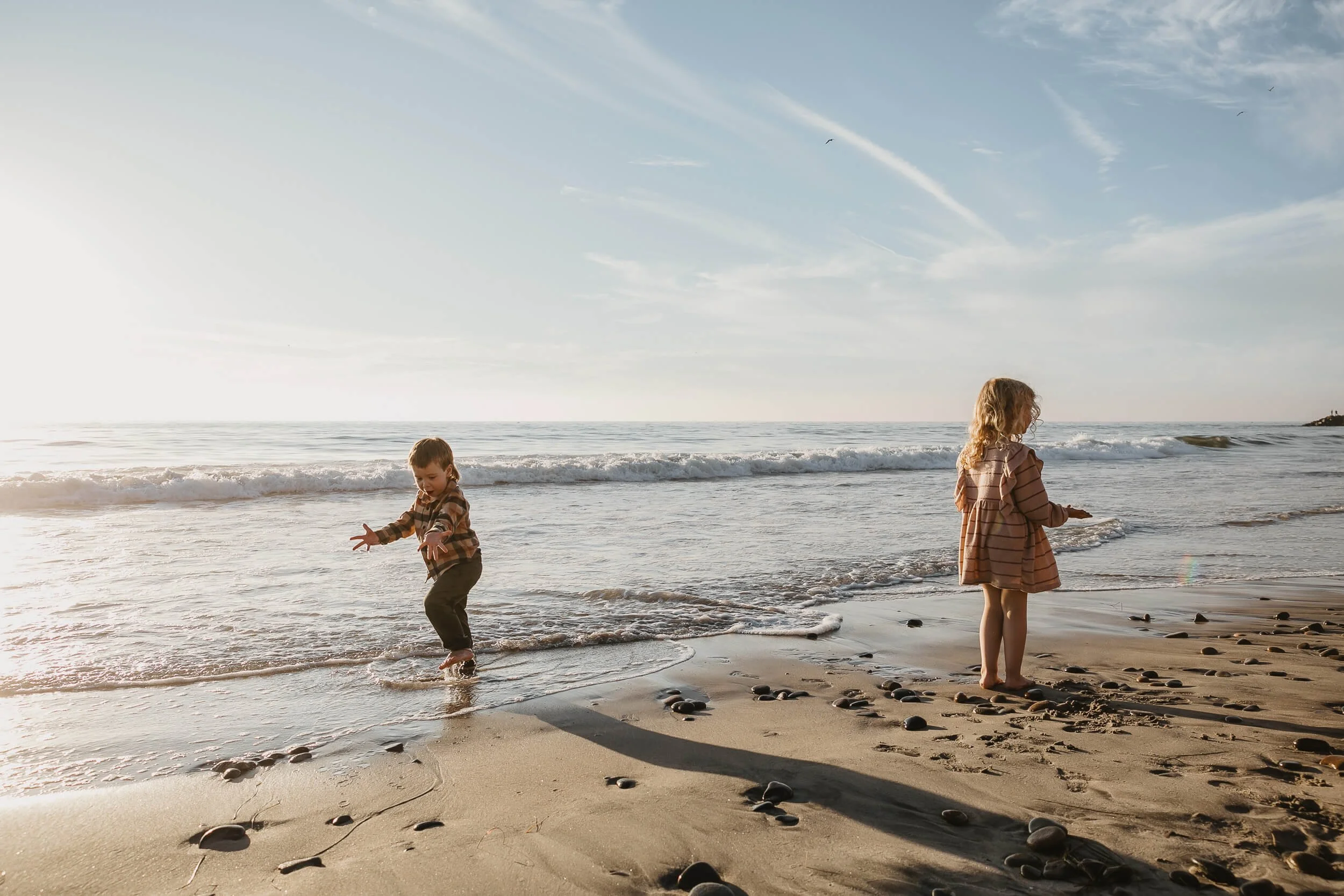 Children playing by the ocean during a sunset Carlsbad Beach Family Photography Session in Southern California