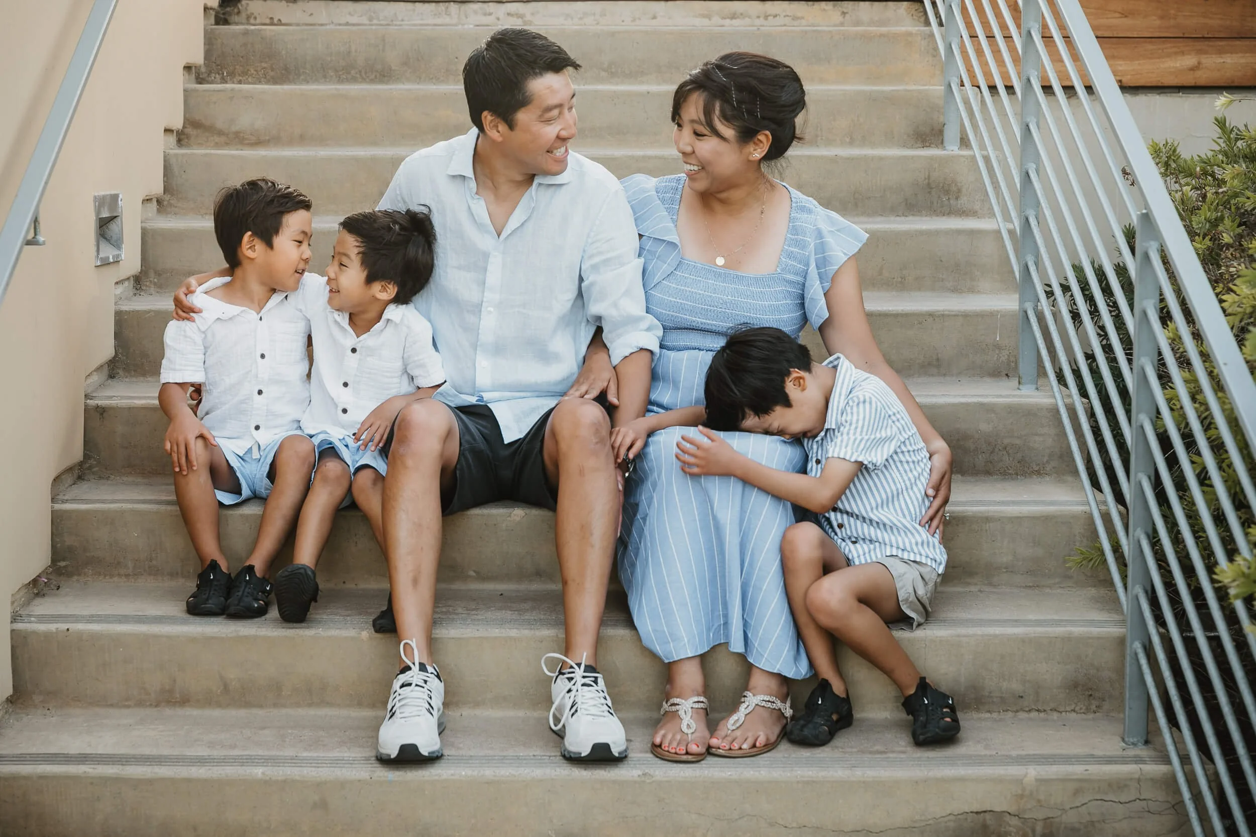 Candid shot of family having fun with each other sitting on the stairs on their La Jolla Shores and Scripps Pier Family Photography in San Diego