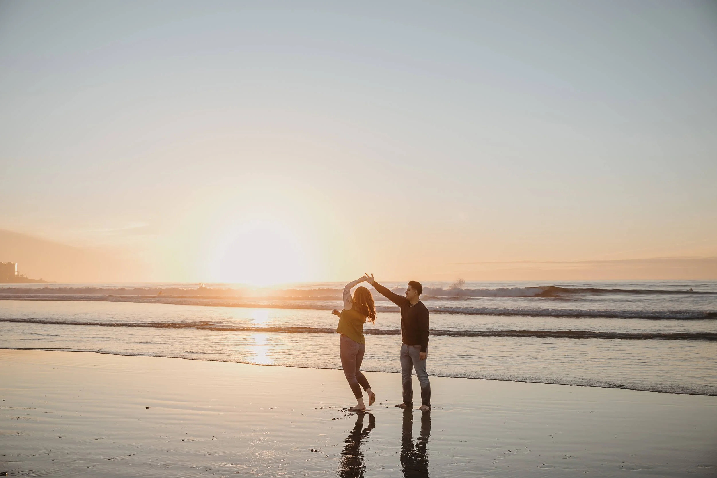 Man spinning his fiancee during San Diego sunset at La Jolla Shores and Scripps Pier Family Photography session