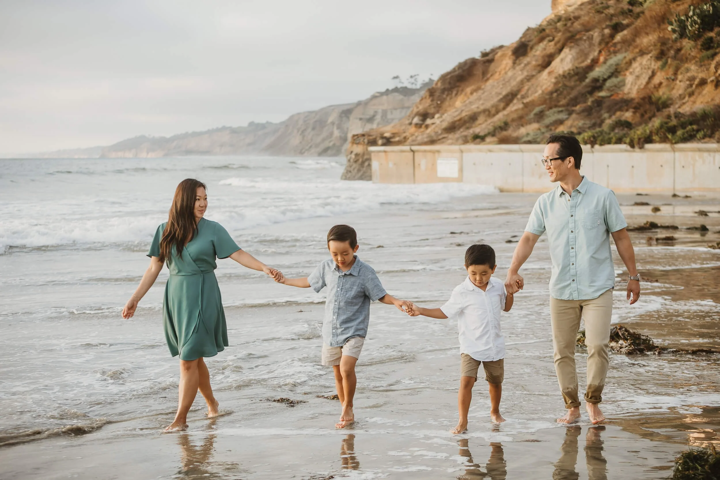 Family of four candid walking shot during La Jolla Shores and Scripps Pier Family Photography in San Diego