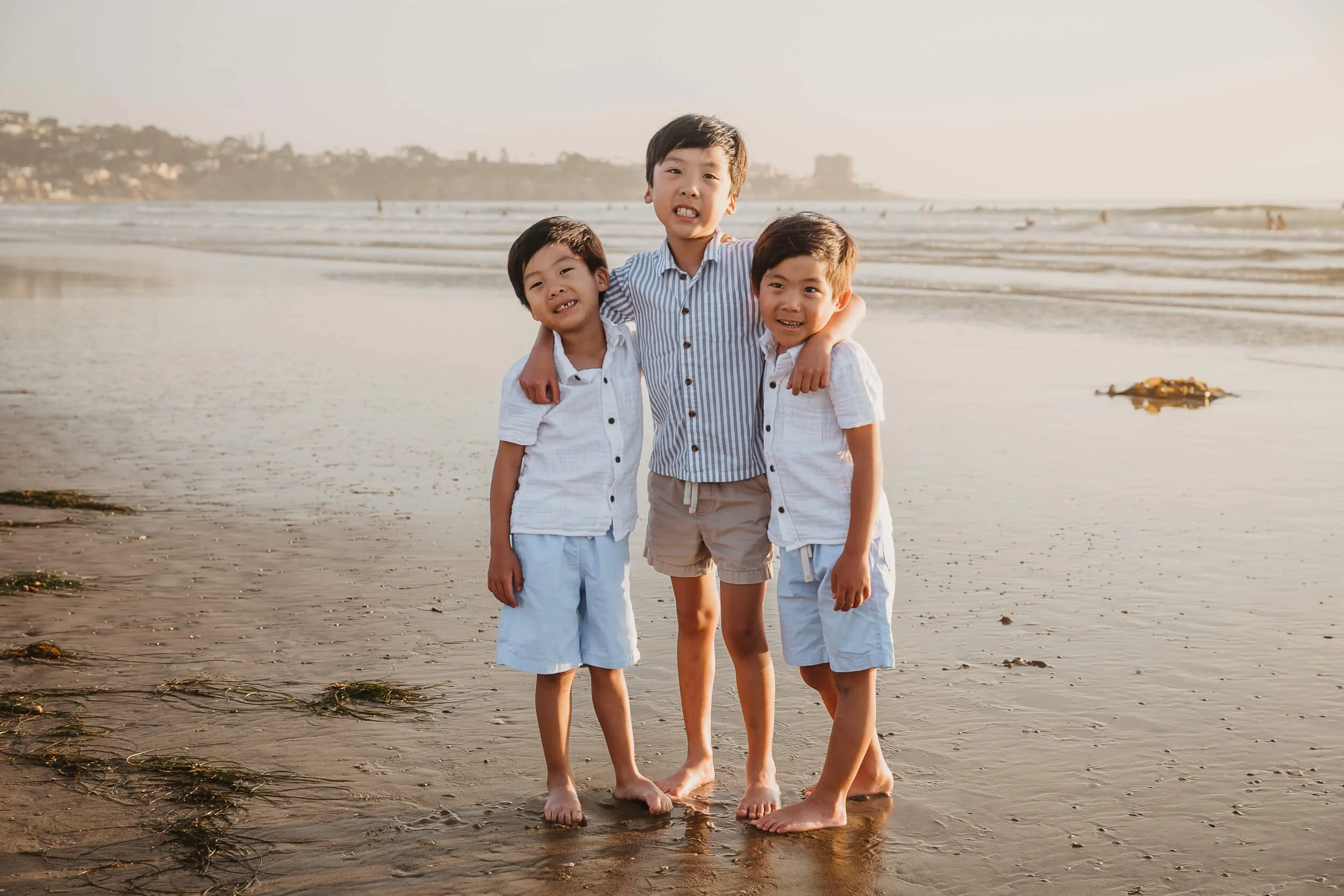 Three boys posing for photo during La Jolla Shores and Scripps Pier Family Photography in San Diego