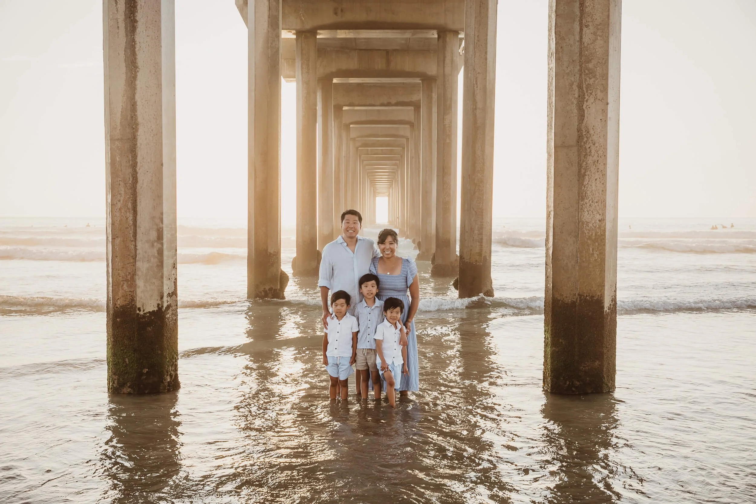 Parents and kids under the Scripps pier in La Jolla Shores for San Diego family mini session