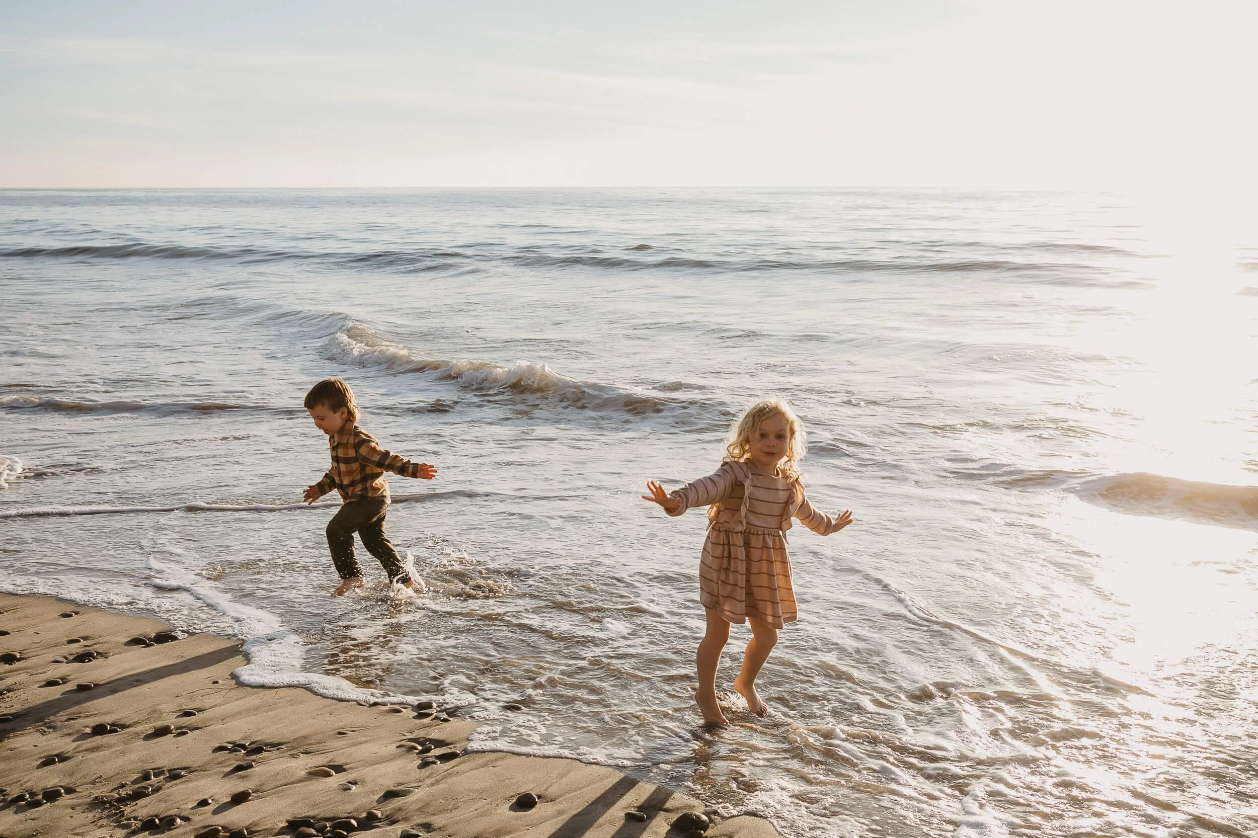 Kids running through the waves during a fun Carlsbad Beach Family Photography Session