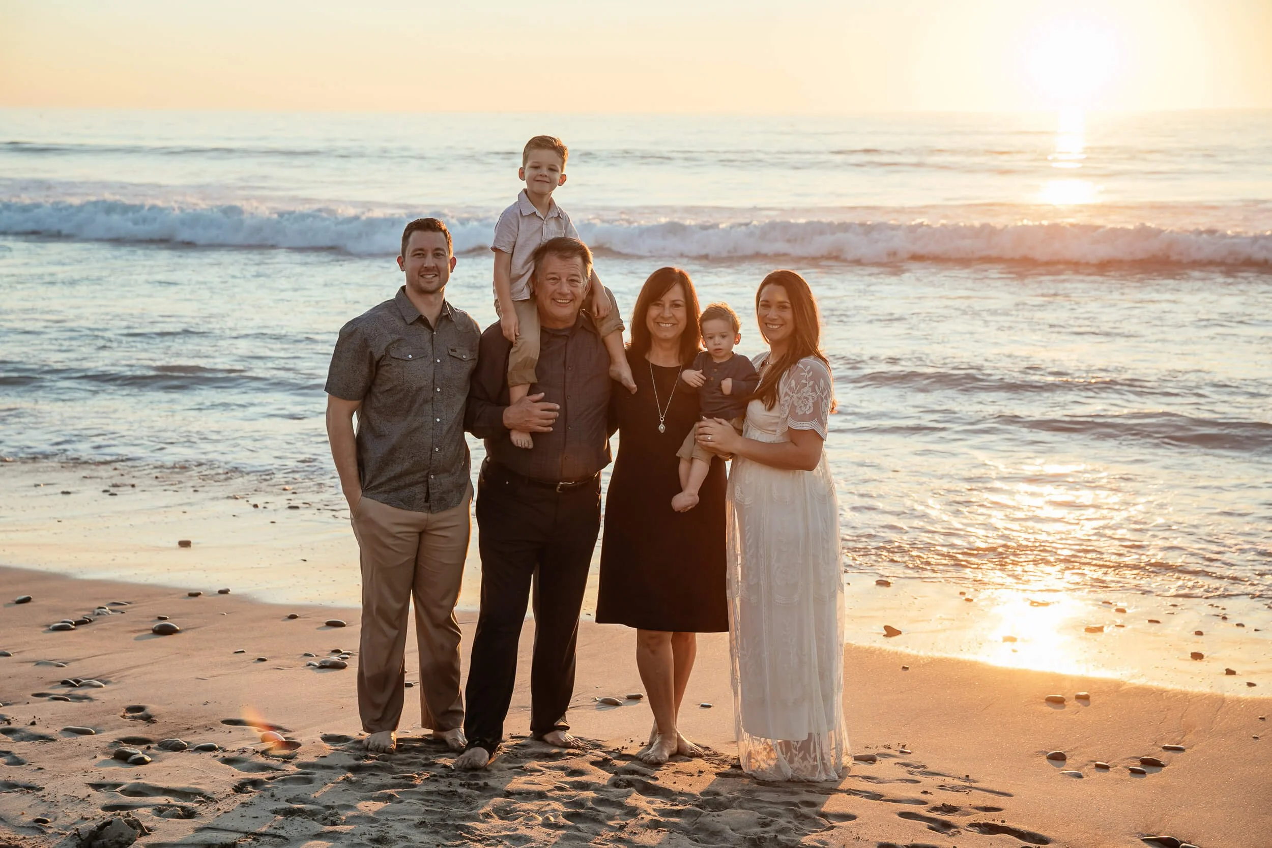 Family portrait during golden hour at the beach photographed by a Carlsbad wedding photographer
