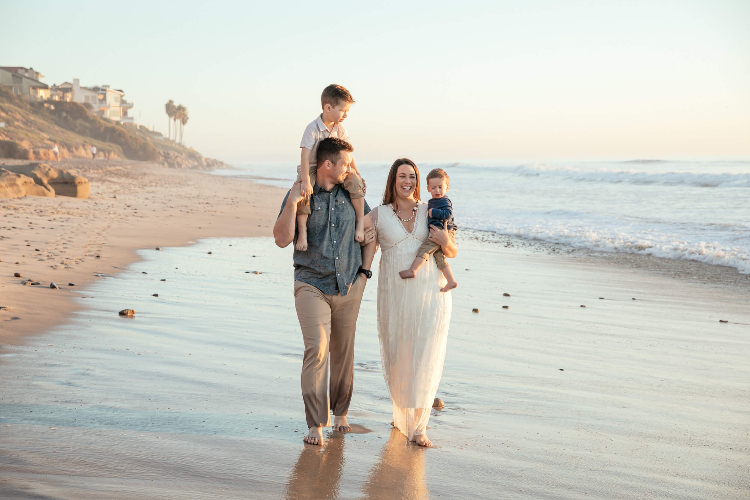 Parents walking with children by the ocean during a Carlsbad Beach Family Photography Session