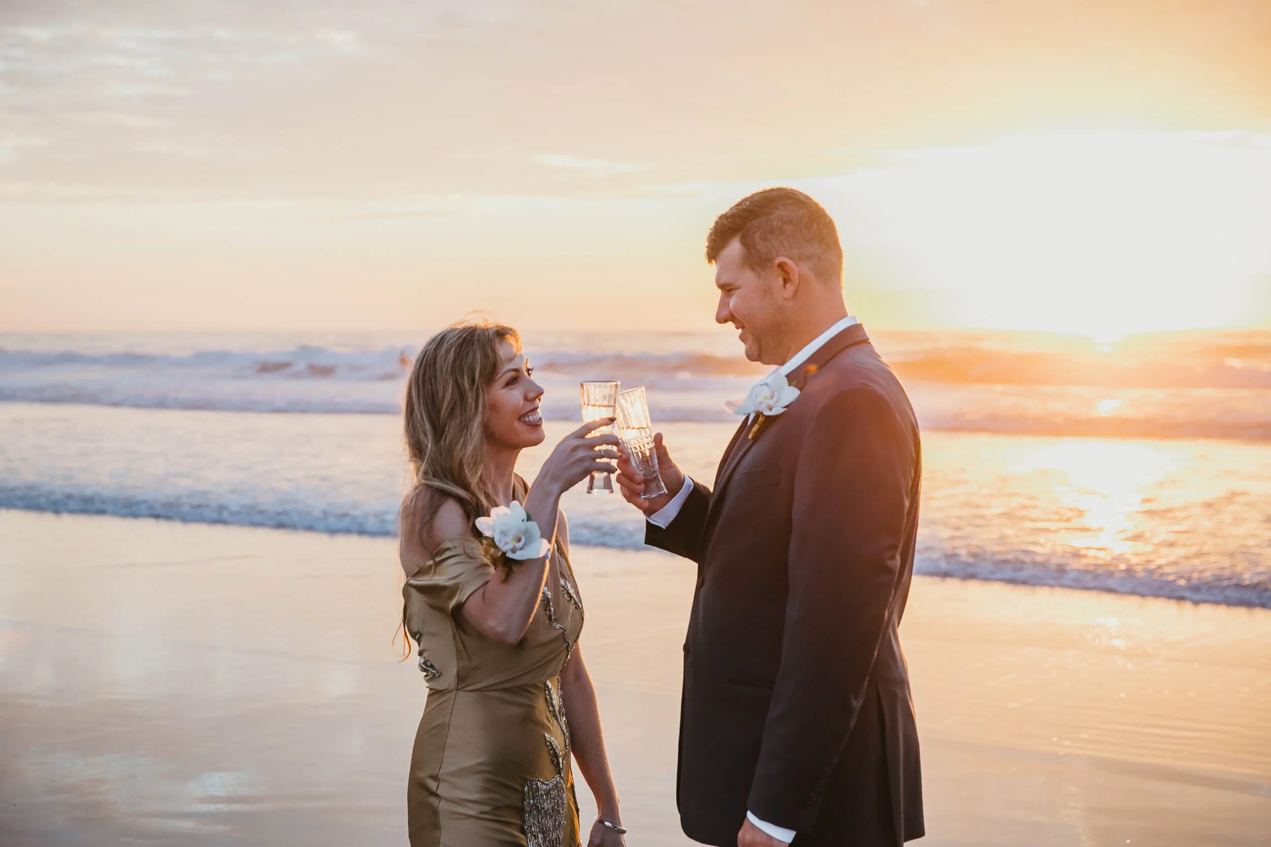 Couple with Champagne glasses toasting for their wedding anniversary at La Jolla Shores and Scripps Pier Family Photography in San Diego