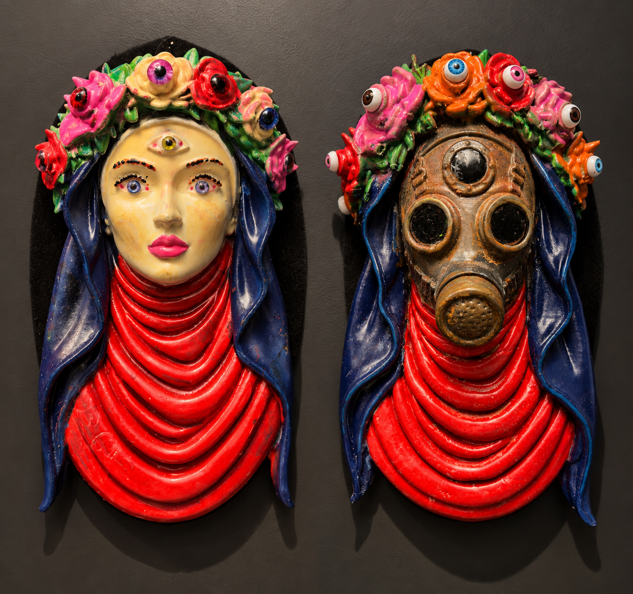 Two colorful masks, one depicting a woman with a third eye, the other a gas mask, both adorned with flowers, against a dark background.