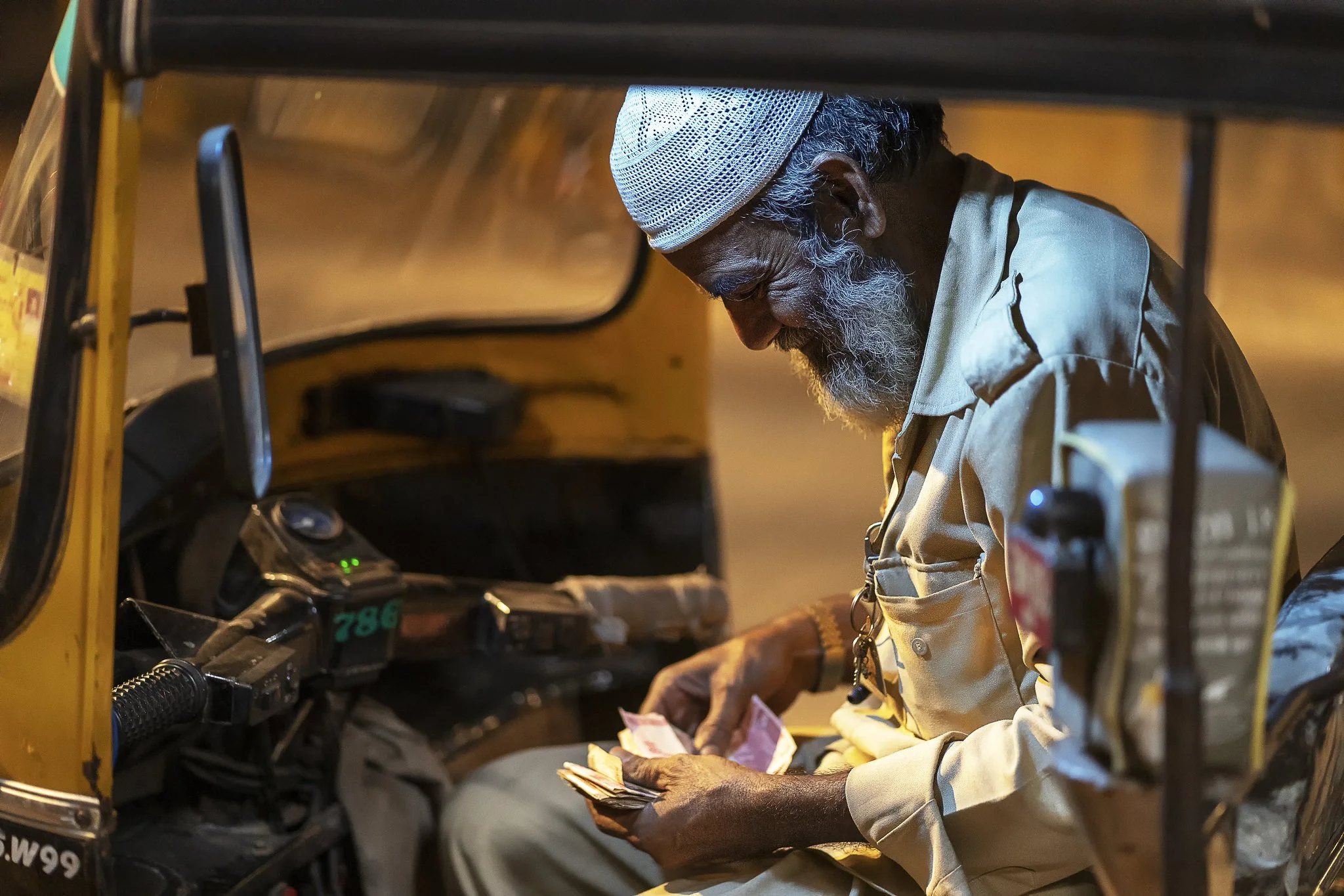 A rickshawala counting money.