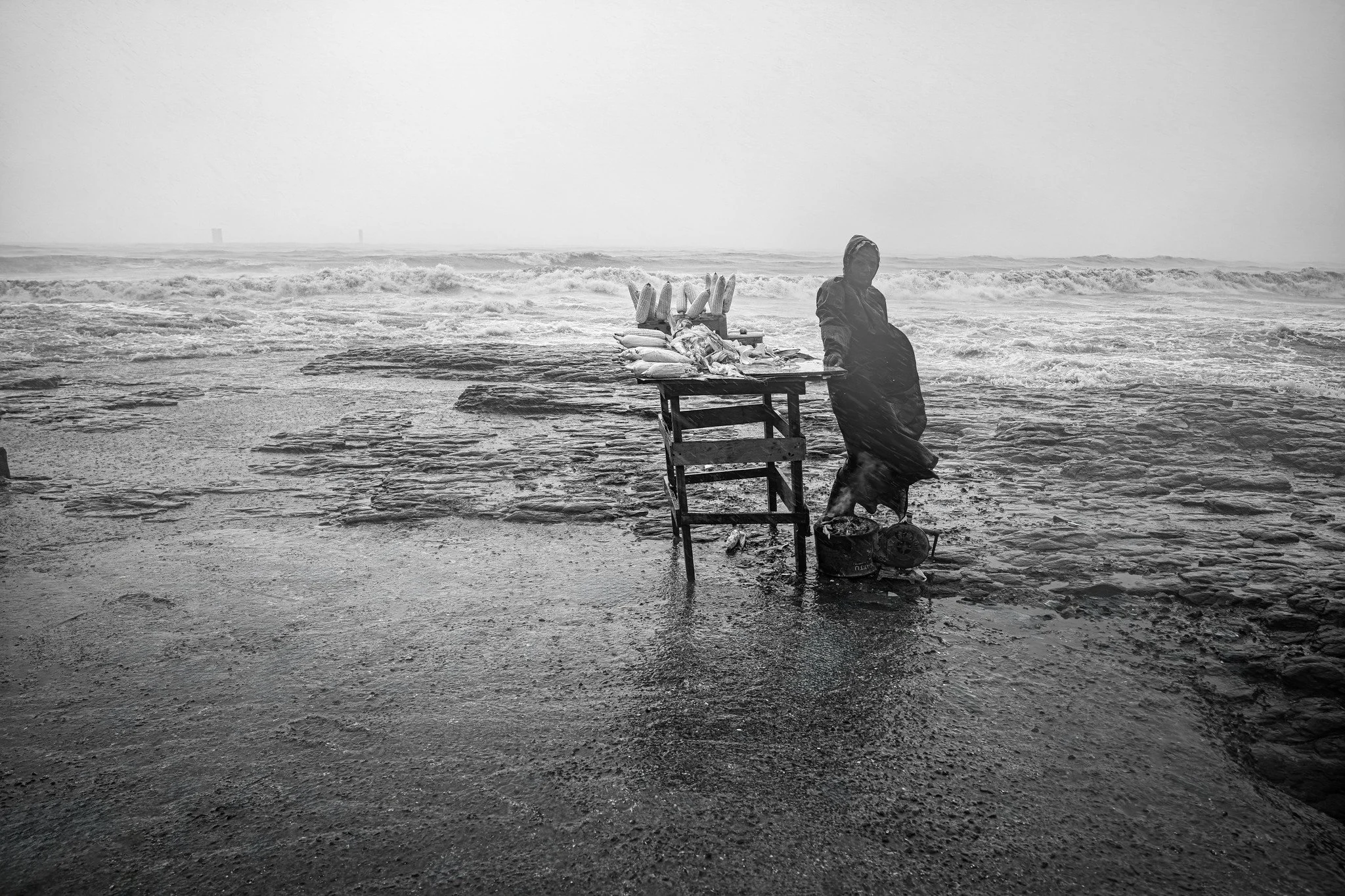 Corn vendor near the sea during monsoon season in Mumbai.