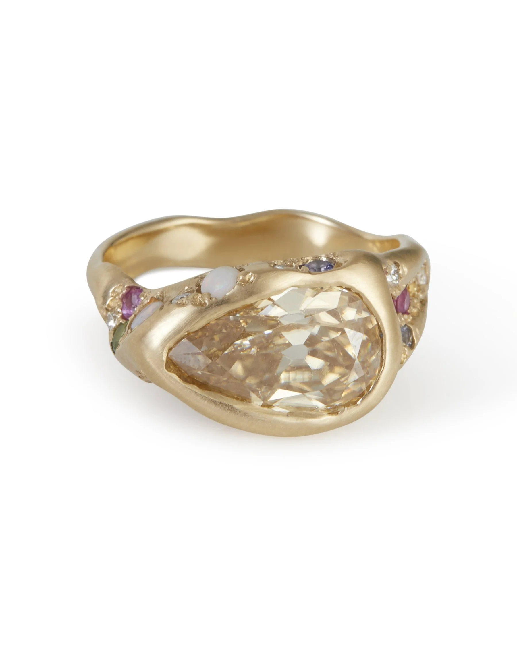 A pear shaped honey colours stones set east-west in a molten gold ring with colourful side stones
