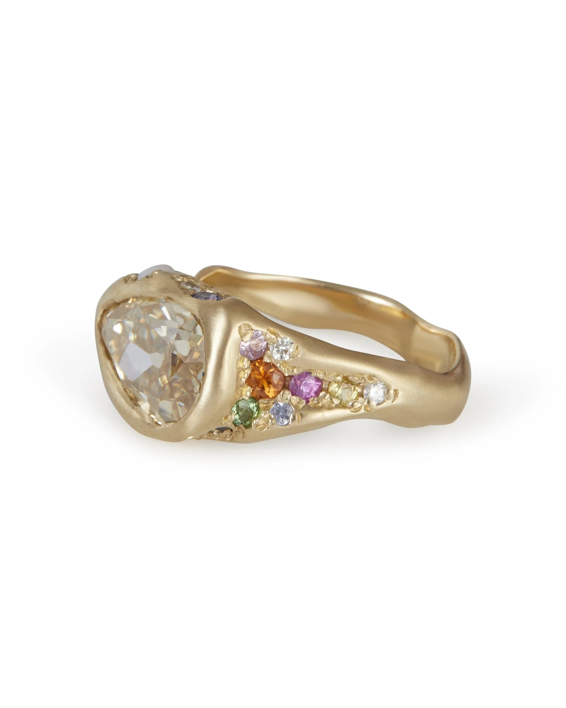 A pear shaped honey colours stones set east-west in a molten gold ring with colourful side stones