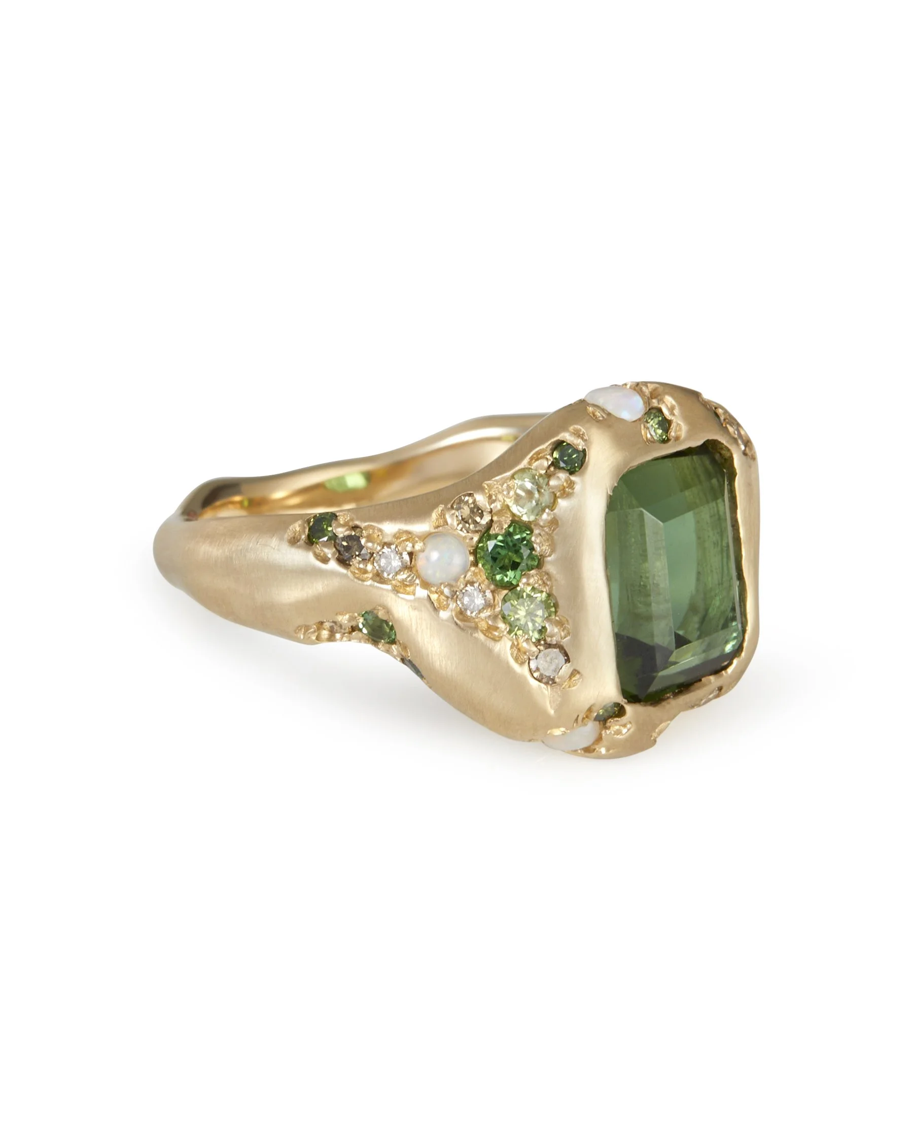 A large green stone ring with intricate green side stone details in molten gold