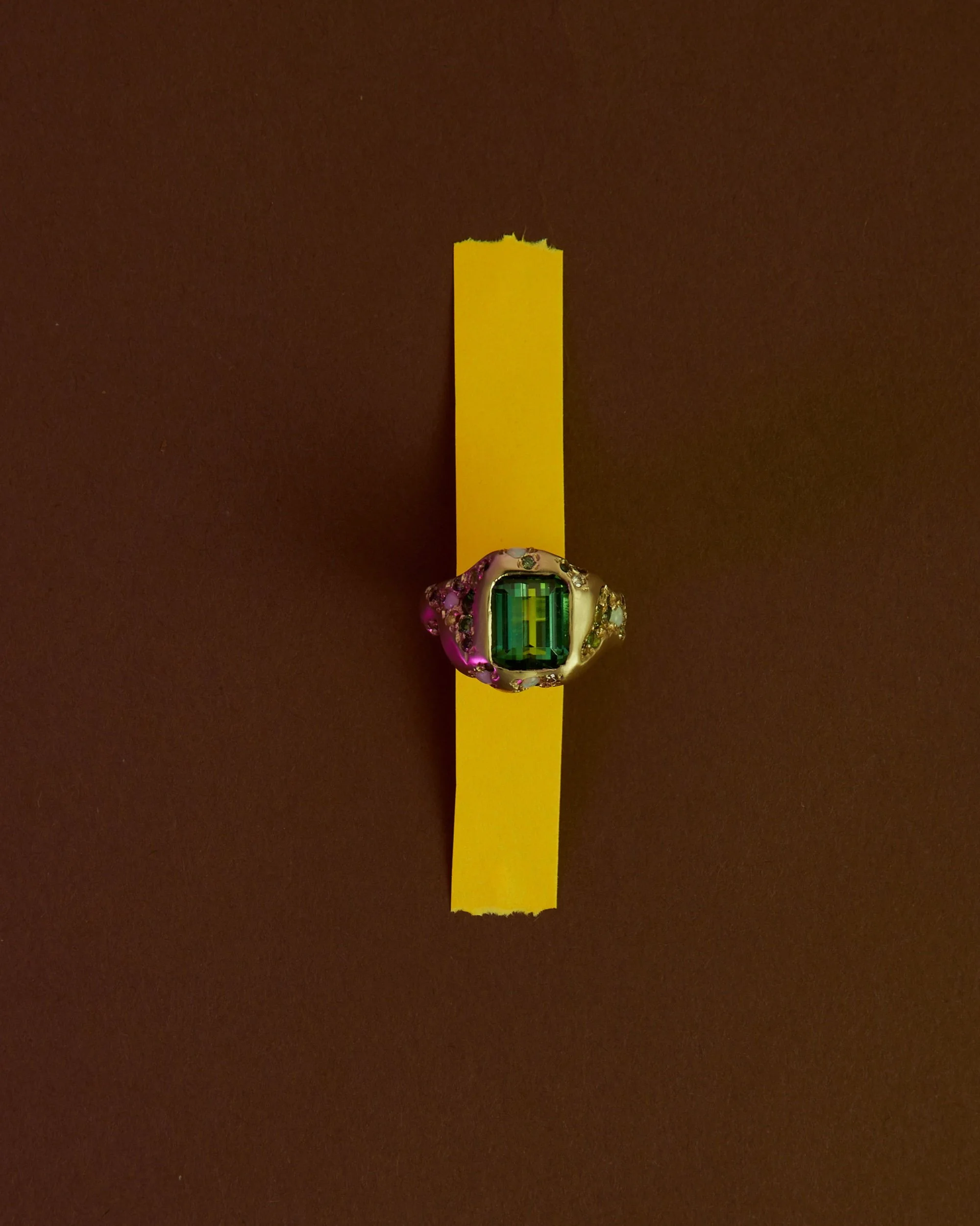 a big green ring on a brown background with orange tape