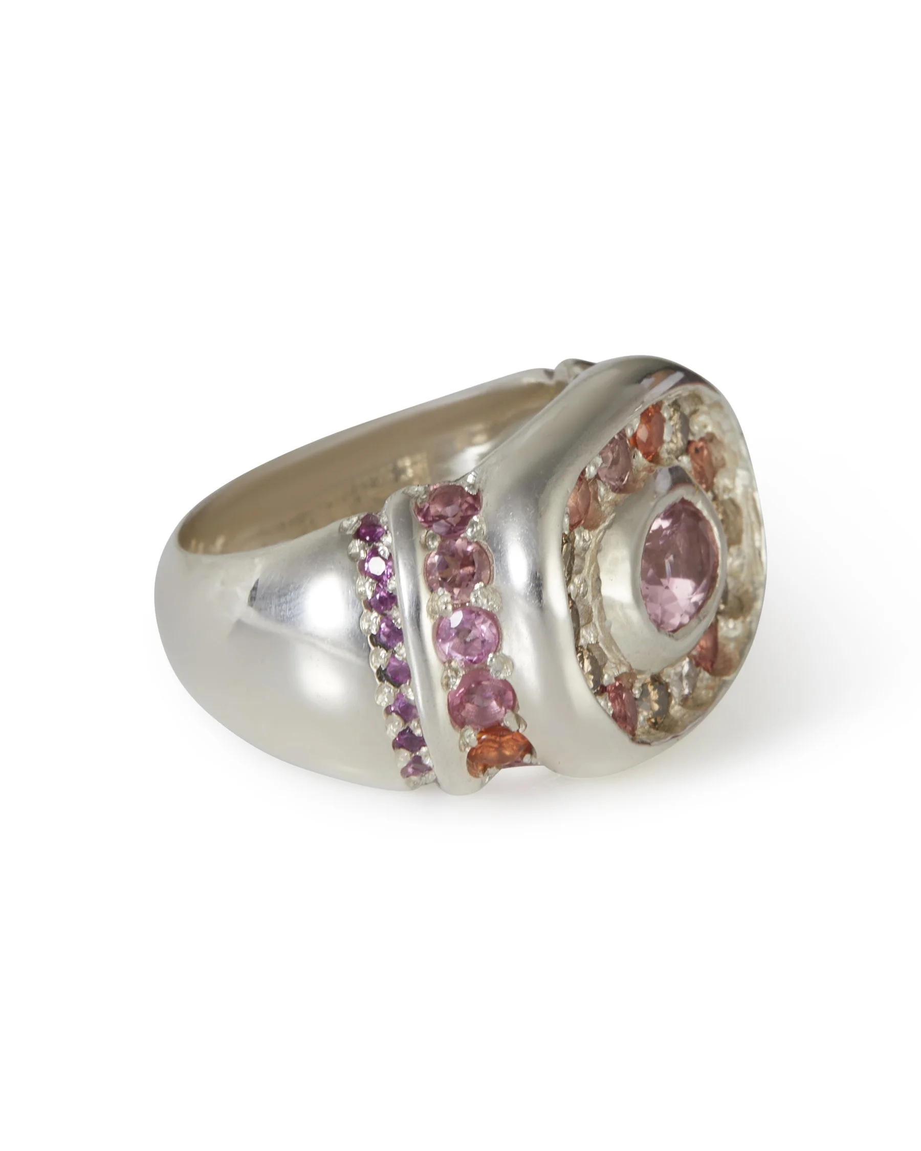 A large silver ring with brown and pink gemstones and orange side stones