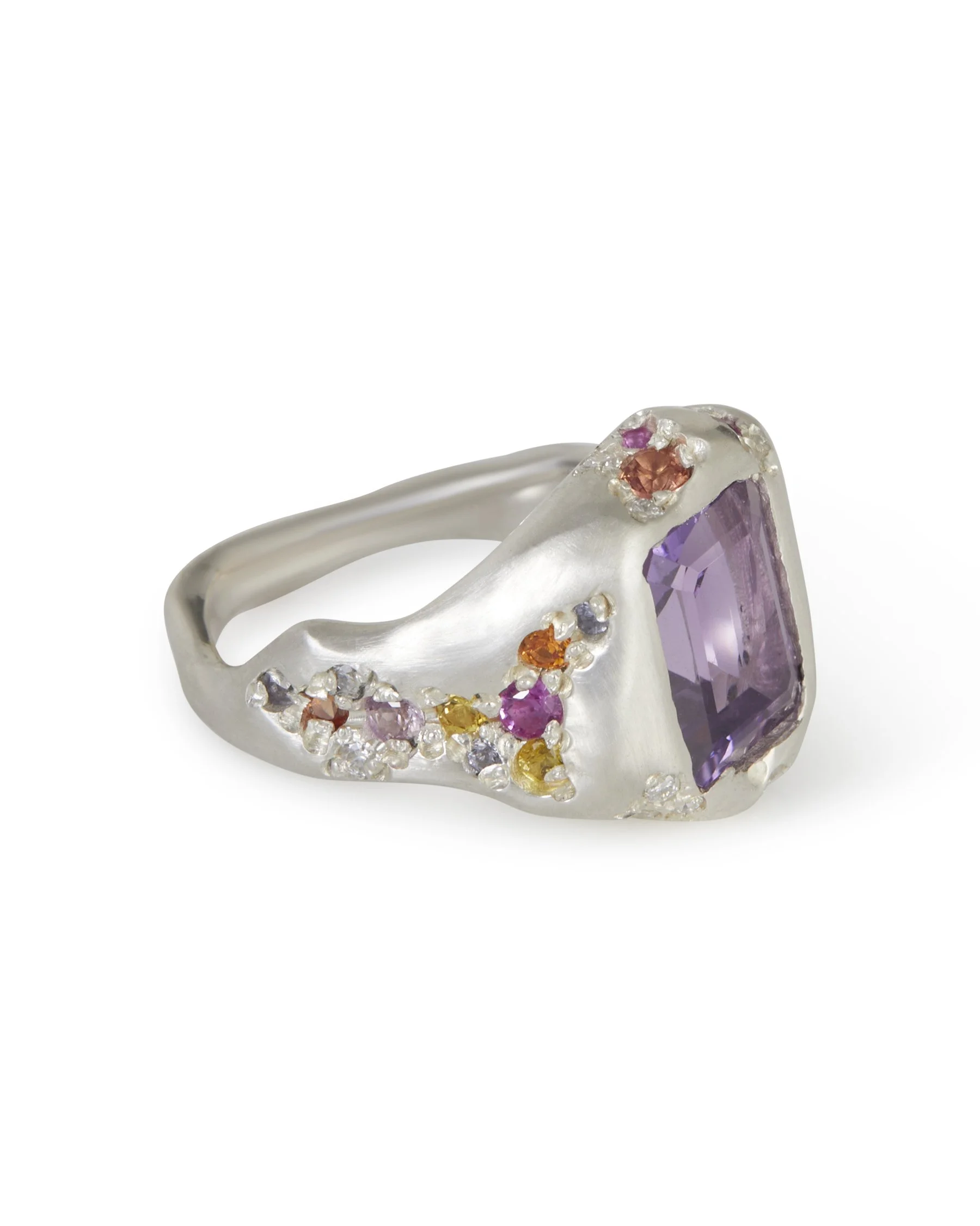 A big silver ring with a rectangular amethyst in the centre and sides stones of pinks oranges and yellows