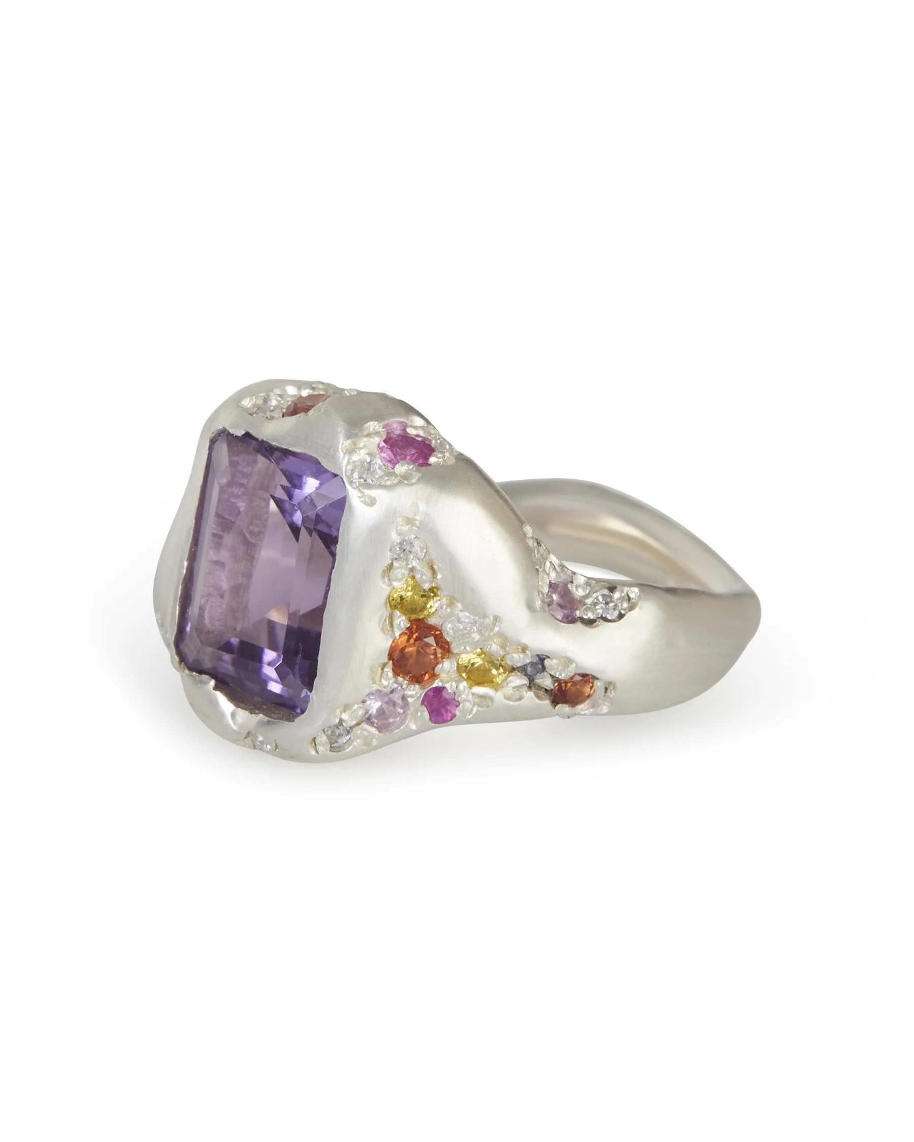 A big silver ring with a rectangular amethyst in the centre and sides stones of pinks oranges and yellows