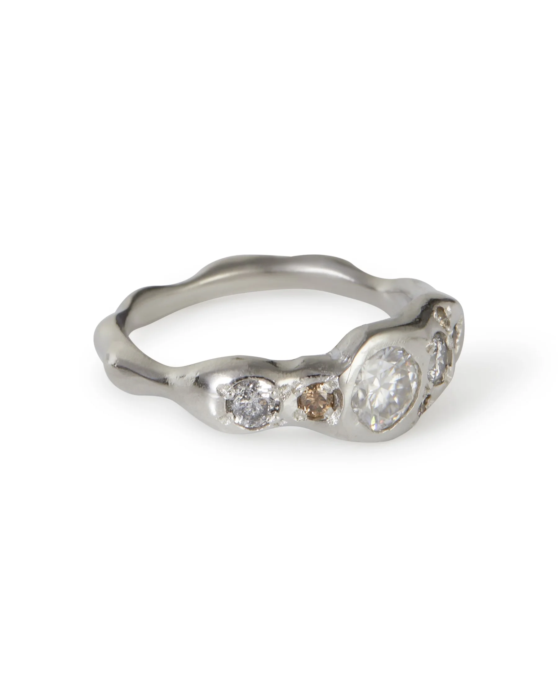 A platinum ring with white grey and brown stones - molten