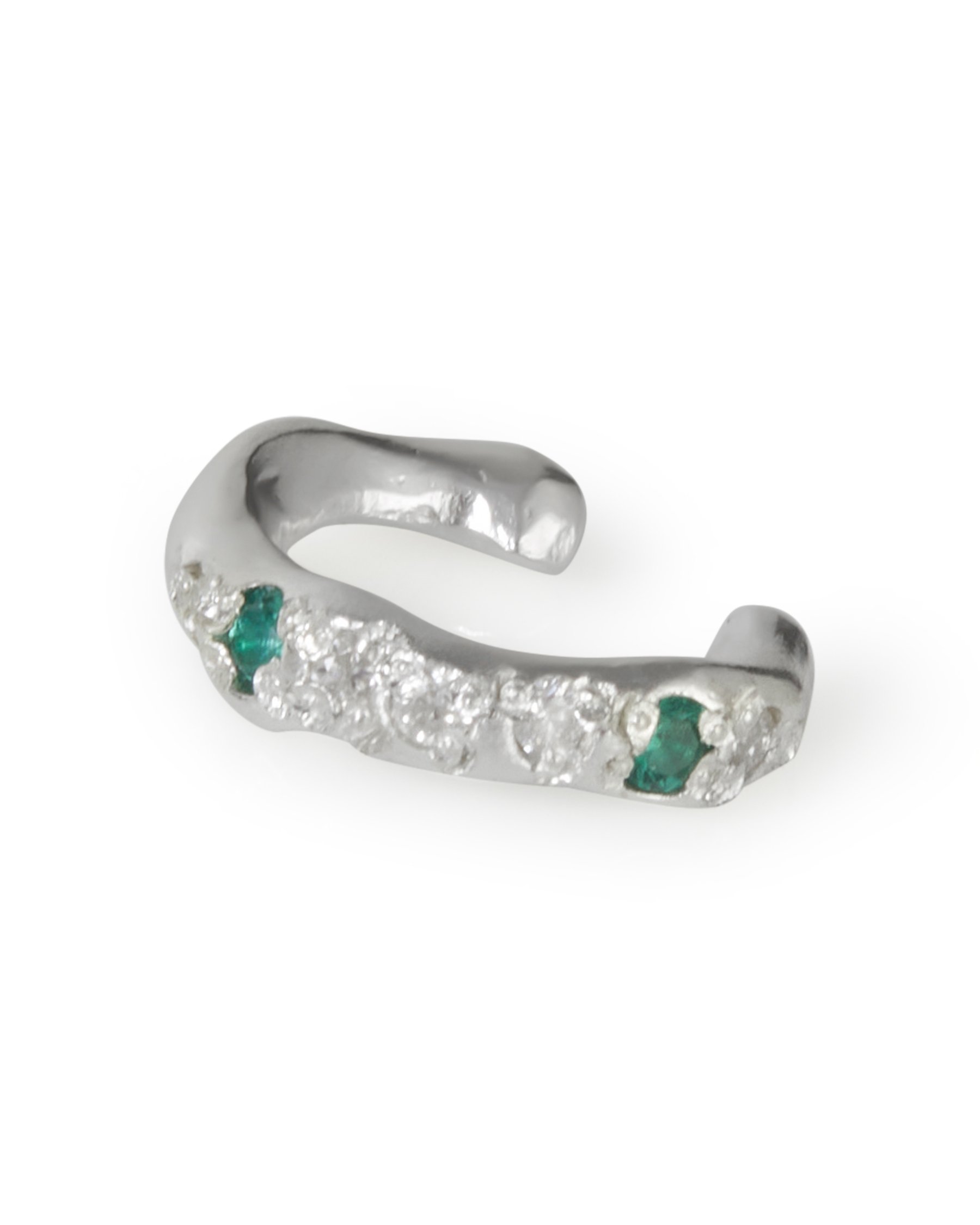 A molten ear cuff with green and white stones on a white background