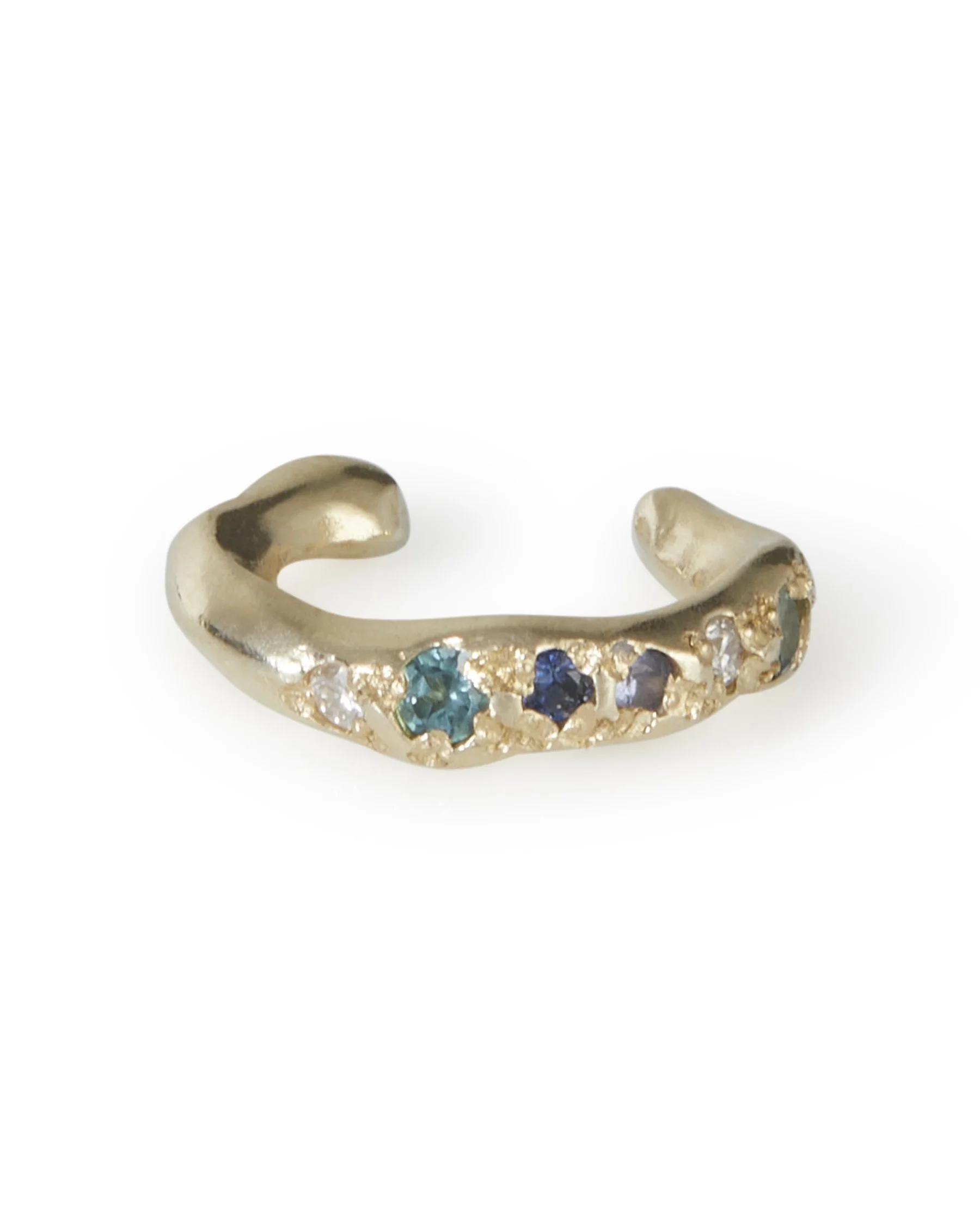 An molten ear cuff with blue toned stones on a white background