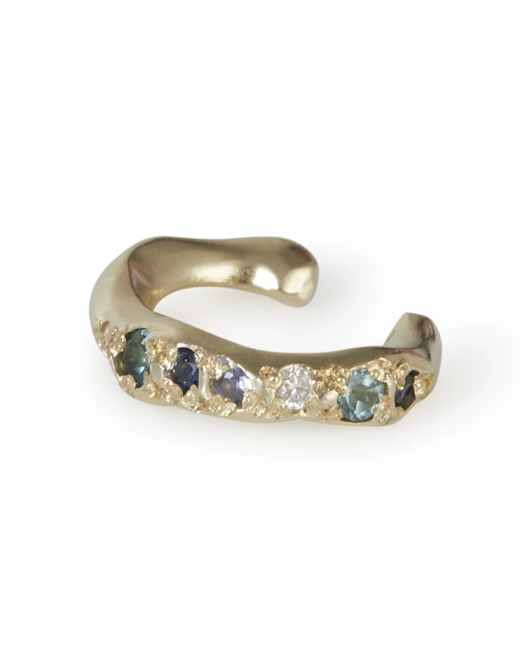 An molten ear cuff with blue toned stones on a white background