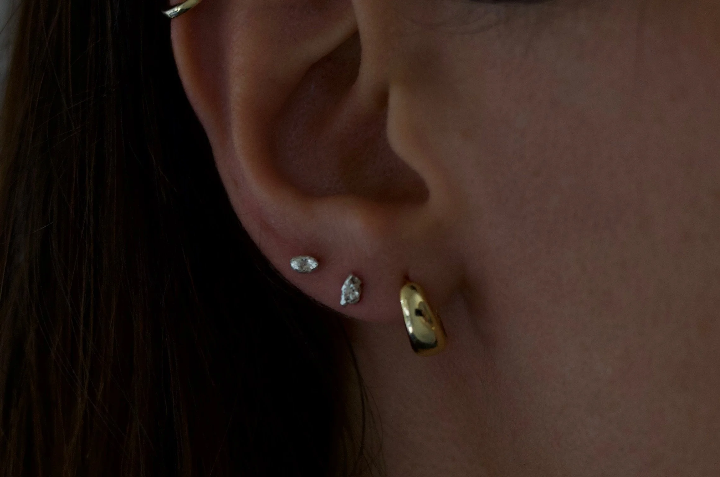 Textured sterling silver studs. The studs are mismatched and in an ear