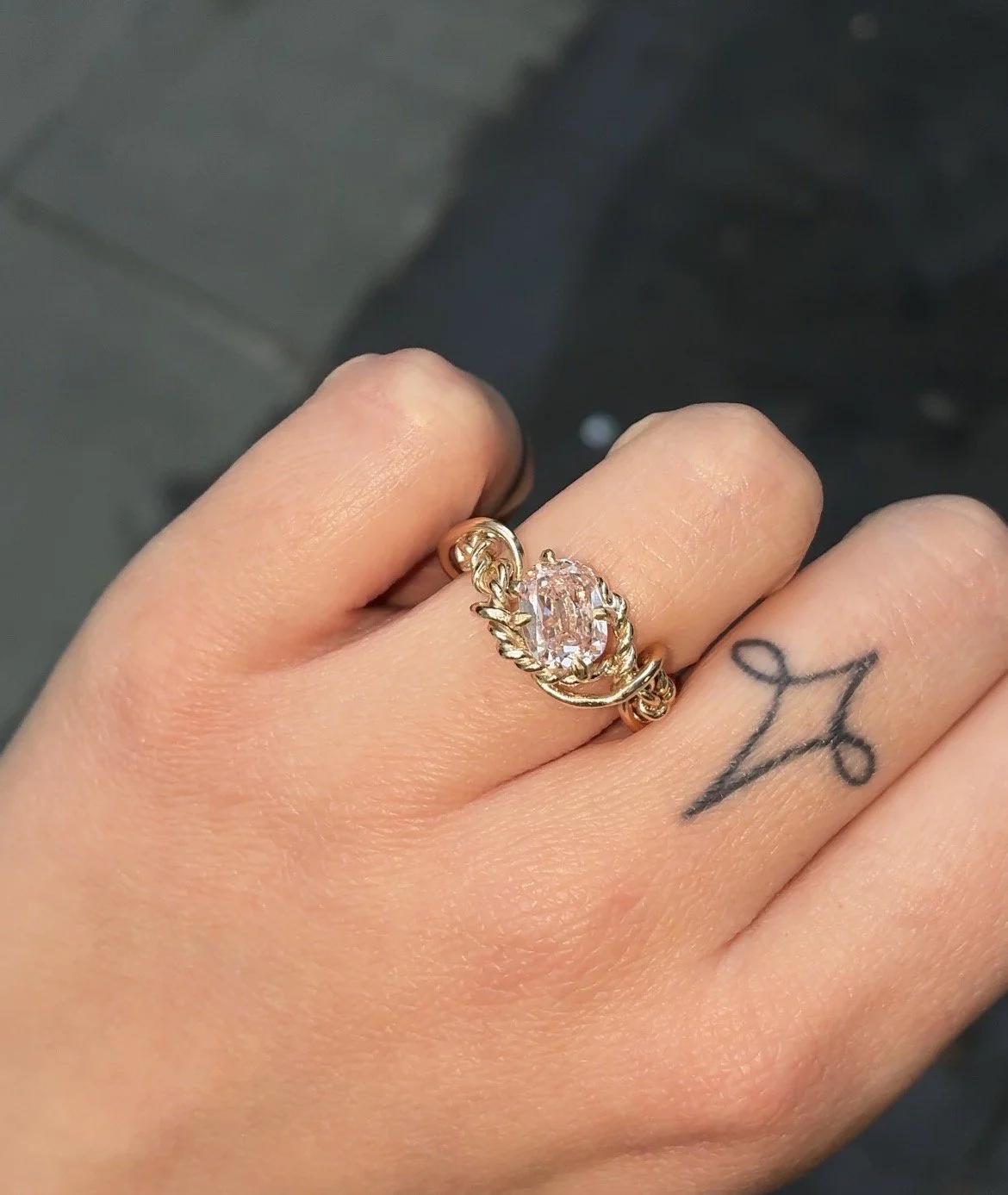 Tangled rope ring with synthetic pink diamond on hand