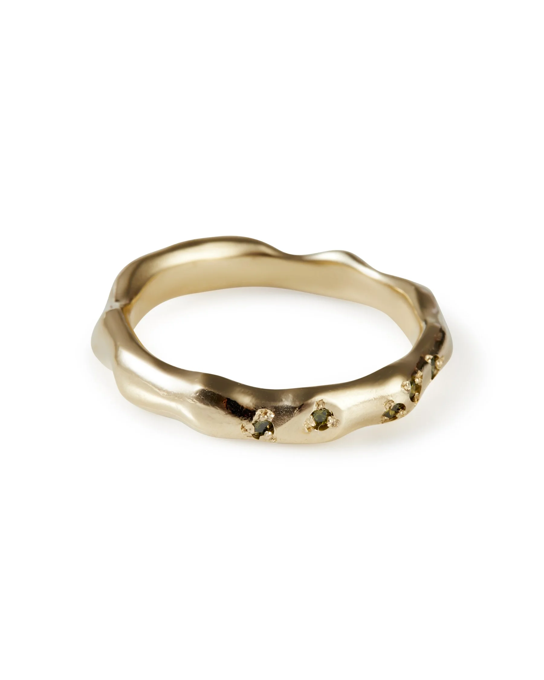 A molten wedding band with green diamonds dotted along it - side view