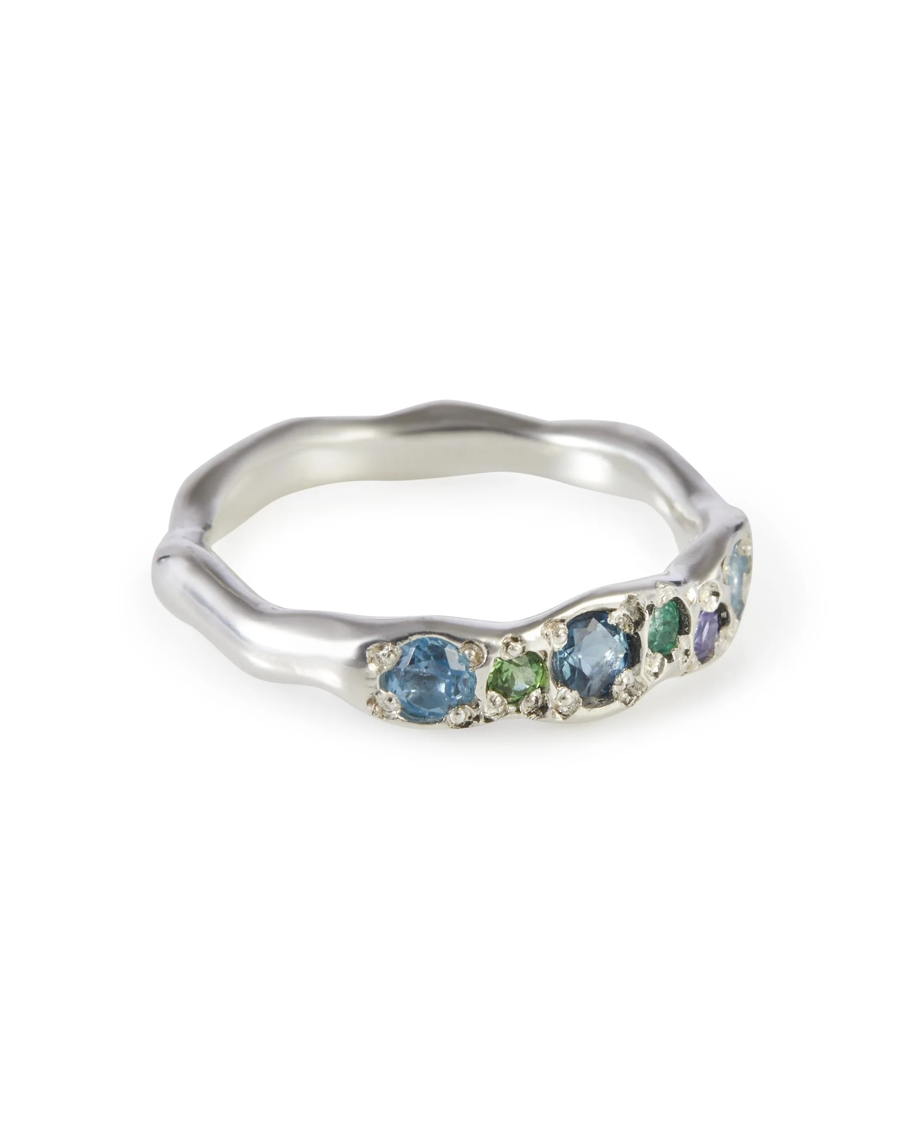 Angled view of the Earth Colne Ring featuring blue and green gemstones including tanzanite, topaz and emerald in sterling silver.