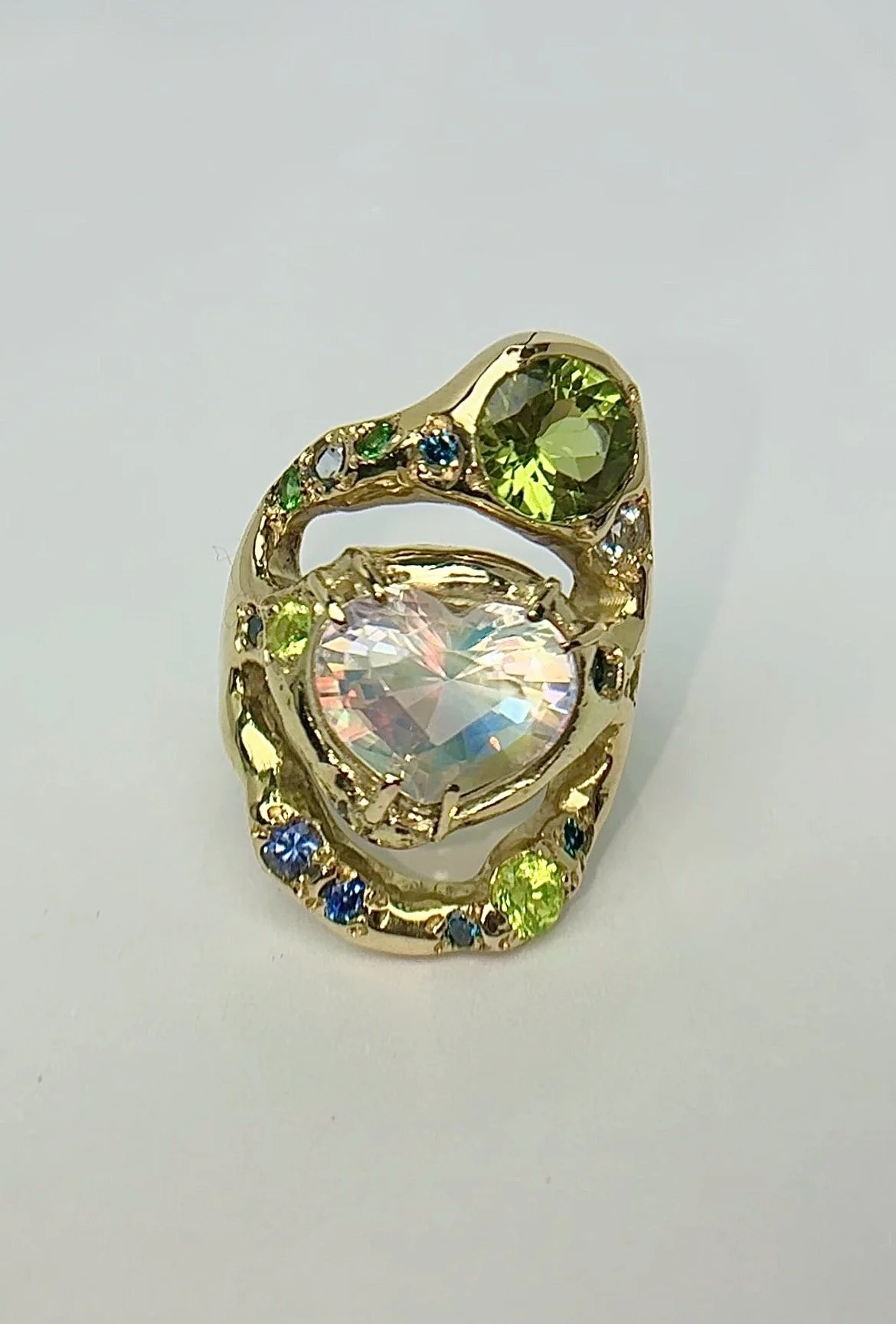Earth Statement Ring - A 3 strand ring with a central heart moonstone and green and blue gemstones in gold