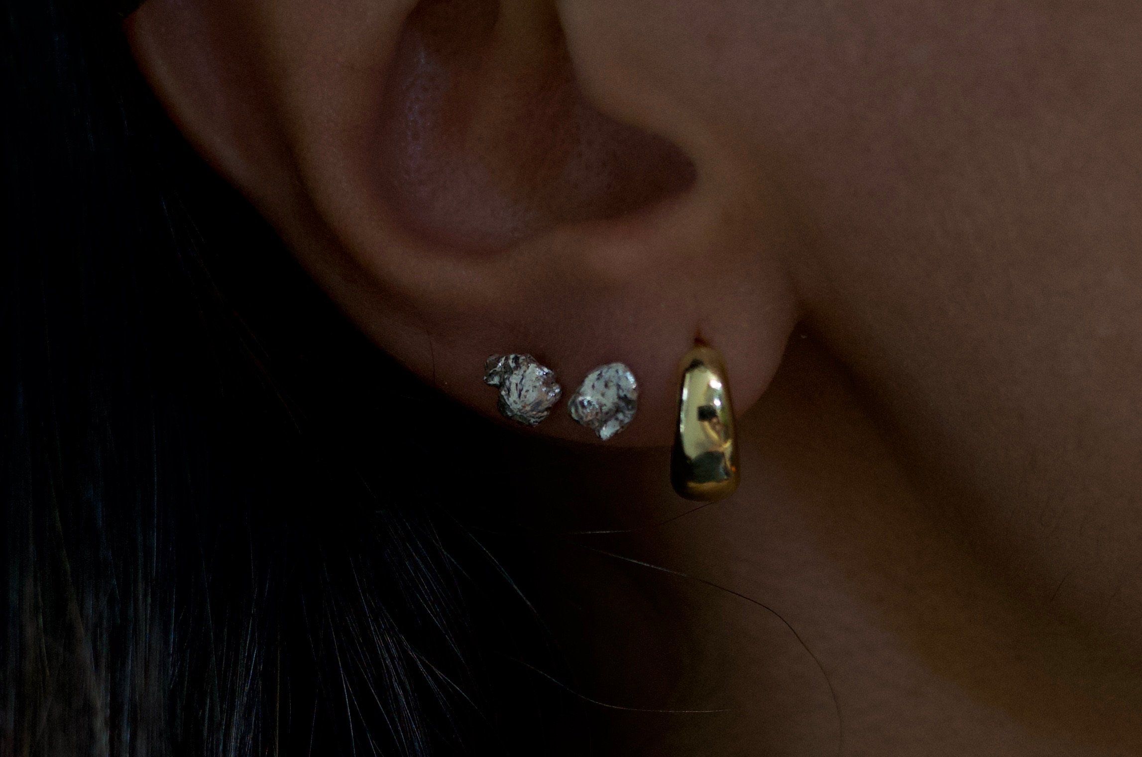 Textured sterling silver studs. The studs are mismatched and in an ear