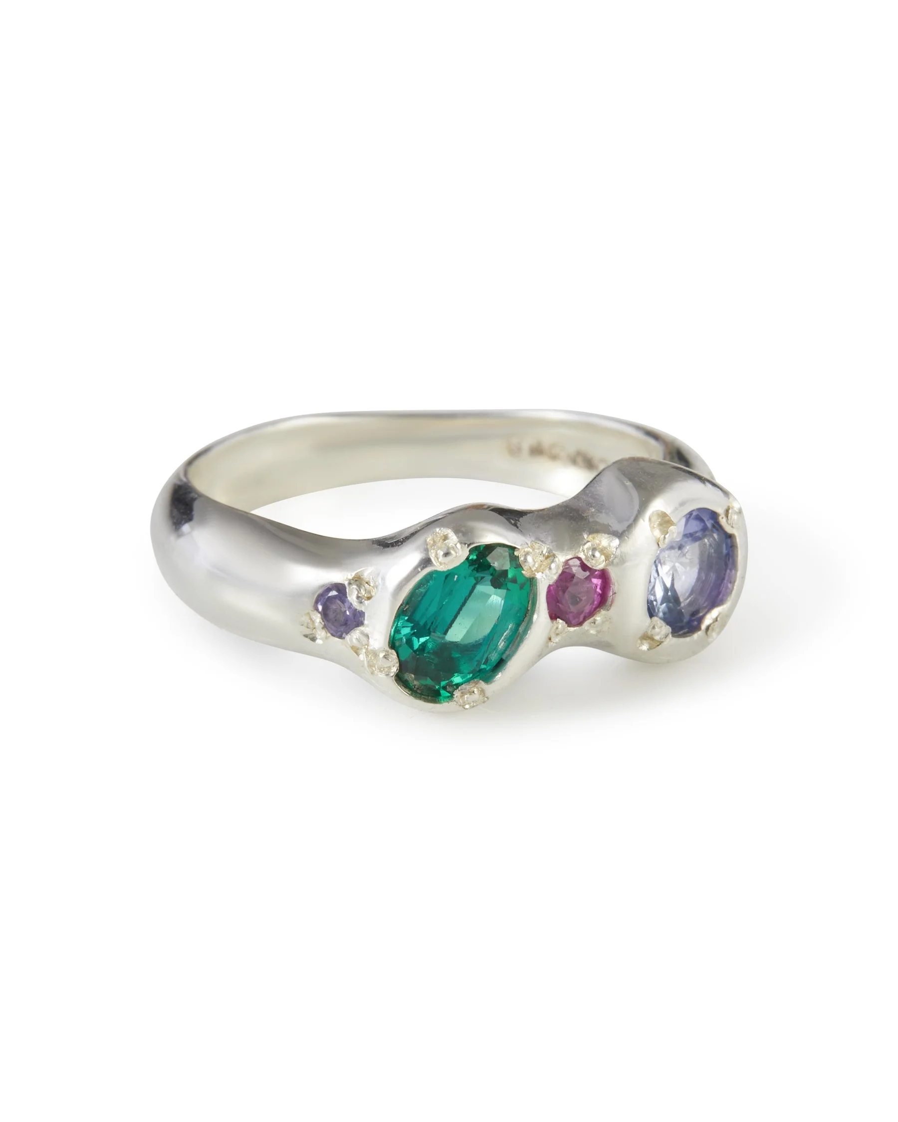 Angled view of the Jester Alien Eyes Ring featuring sapphires, tanzanite and lab grown emerald in sterling silver.