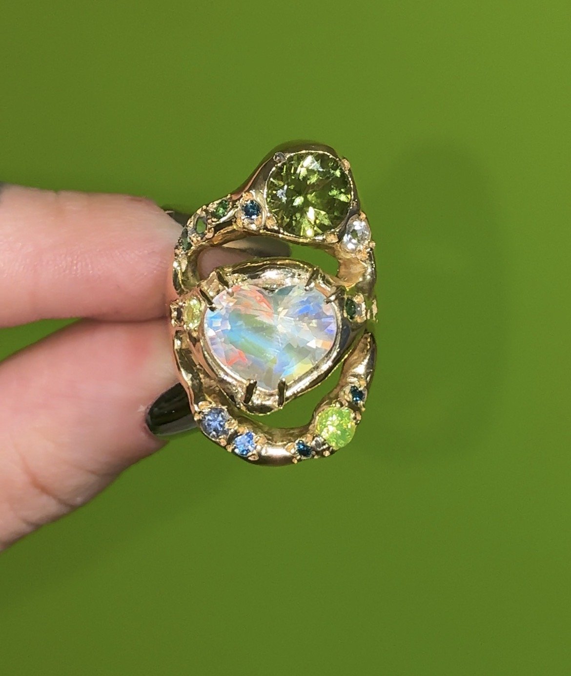 Earth Statement Ring - A 3 strand ring with a central heart moonstone and green and blue gemstones in gold