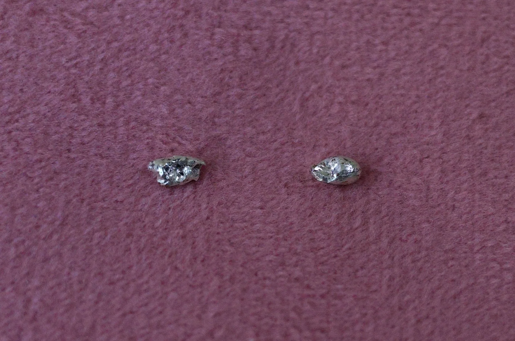 Textured sterling silver studs. The studs are mismatched and in an ear