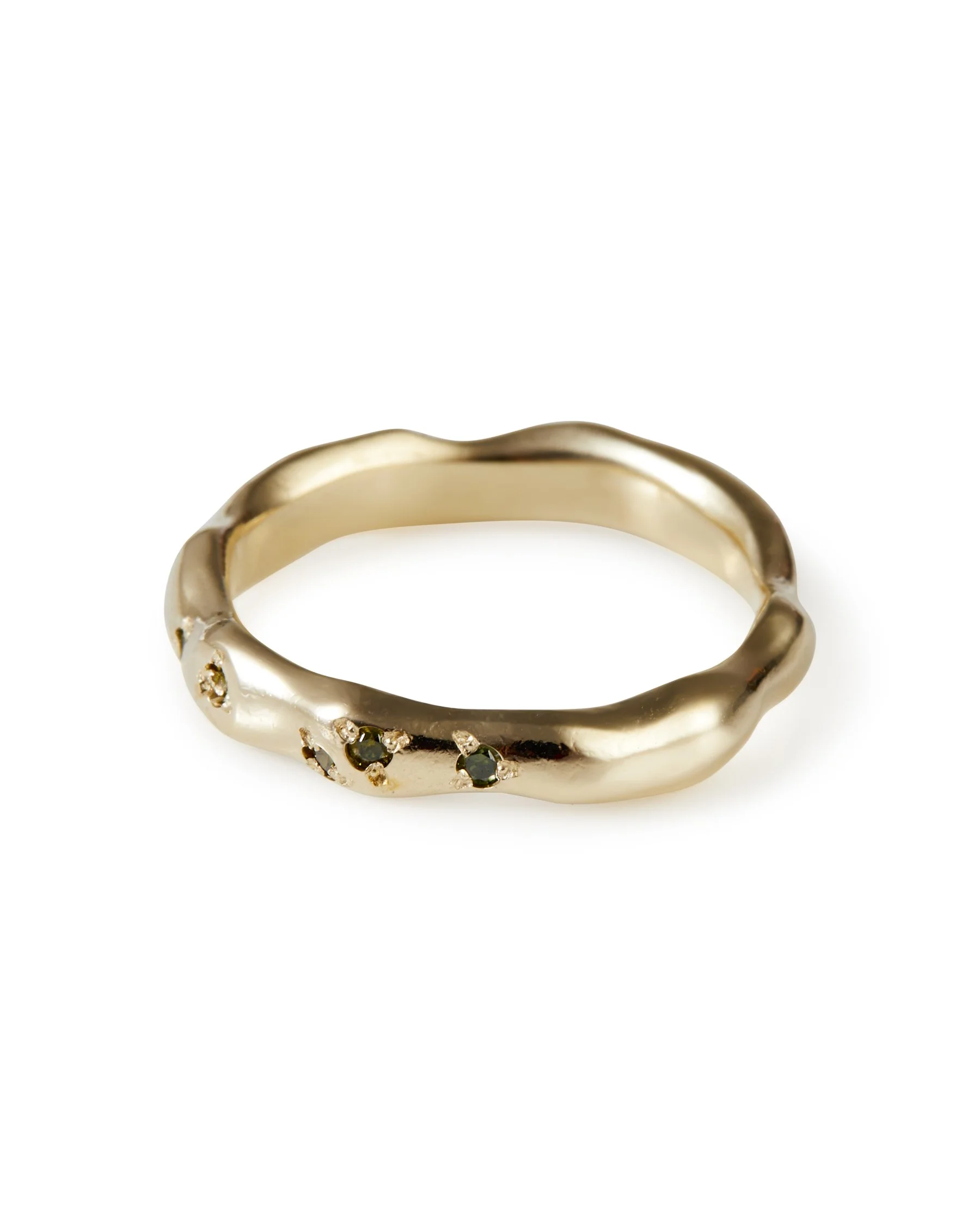 A molten wedding band with green diamonds dotted along it - side view